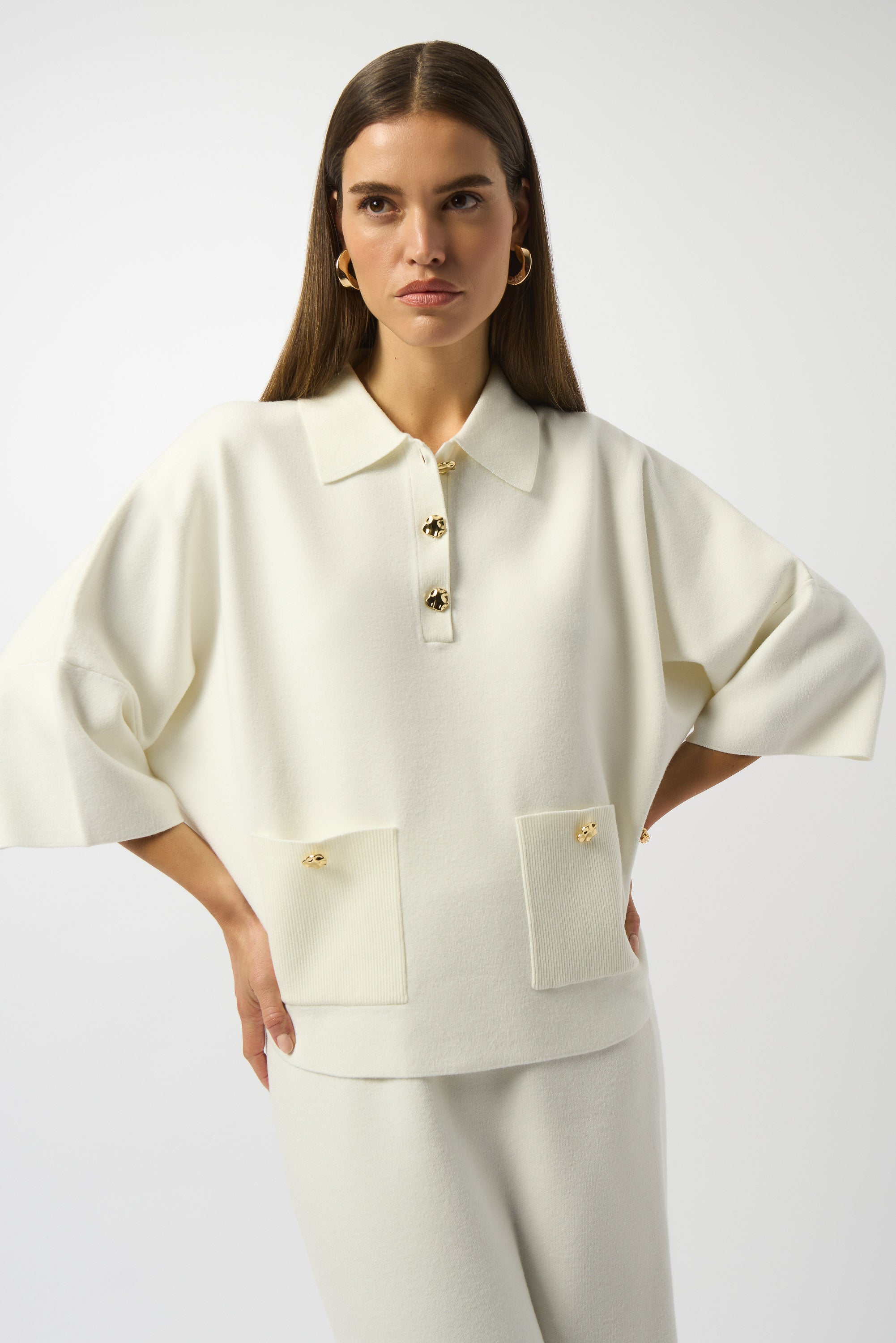 Pearls Boutique|Port Dover Ontario| Joseph Ribkoff | Sweater Knit Boxy Pullover With Polo Collar|253962. Winter white colour. Soft sweater knit pullover featuring a structured boxy fit with a chic polo collar, gold button accents on the placket and front pockets, and elegant three-quarter bell sleeves for a feminine, fluid silhouette.