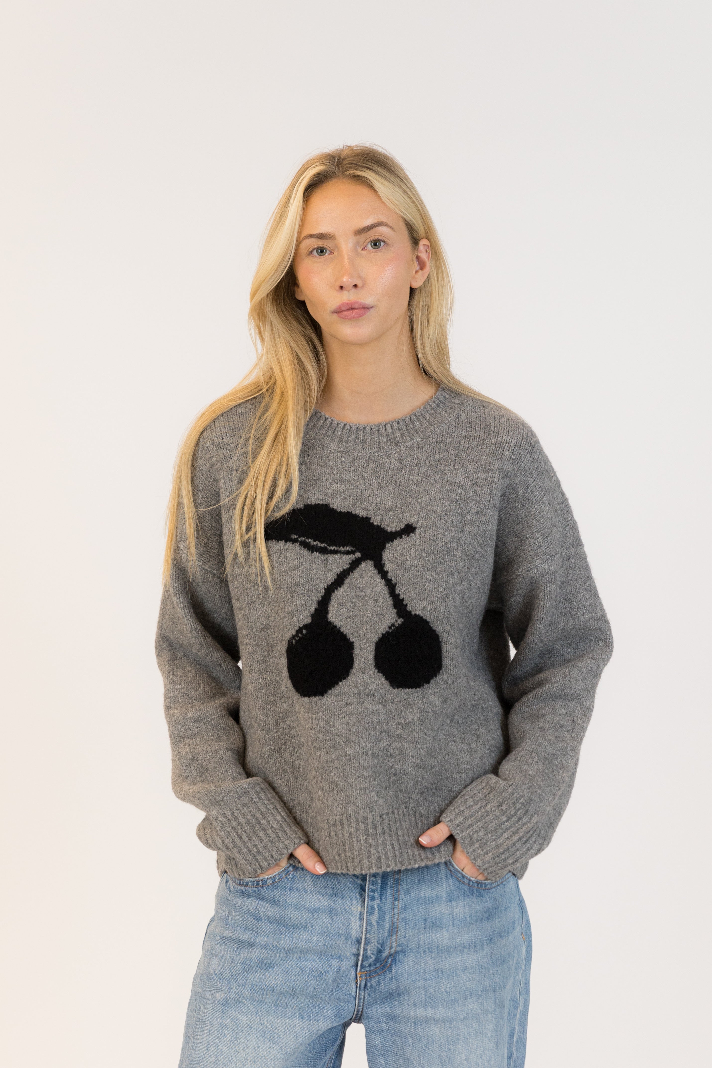 Pearls Boutique| Port Dover Ontario| Lyla + Lux | Lou Crewneck Pullover| women’s crewneck pullover sweater in a charcoal grey knit, featuring playful black cherry embroidery across the front. polyester, acrylic, polyamide, wool, and elastane, this sweater is designed with a classic crew neckline, dropped shoulders, and a relaxed fit for laid-back comfort. The plush, breathable fabric makes it perfect for layering or wearing on its own, adding a subtle yet fun detail to casual fall and winter outfits.