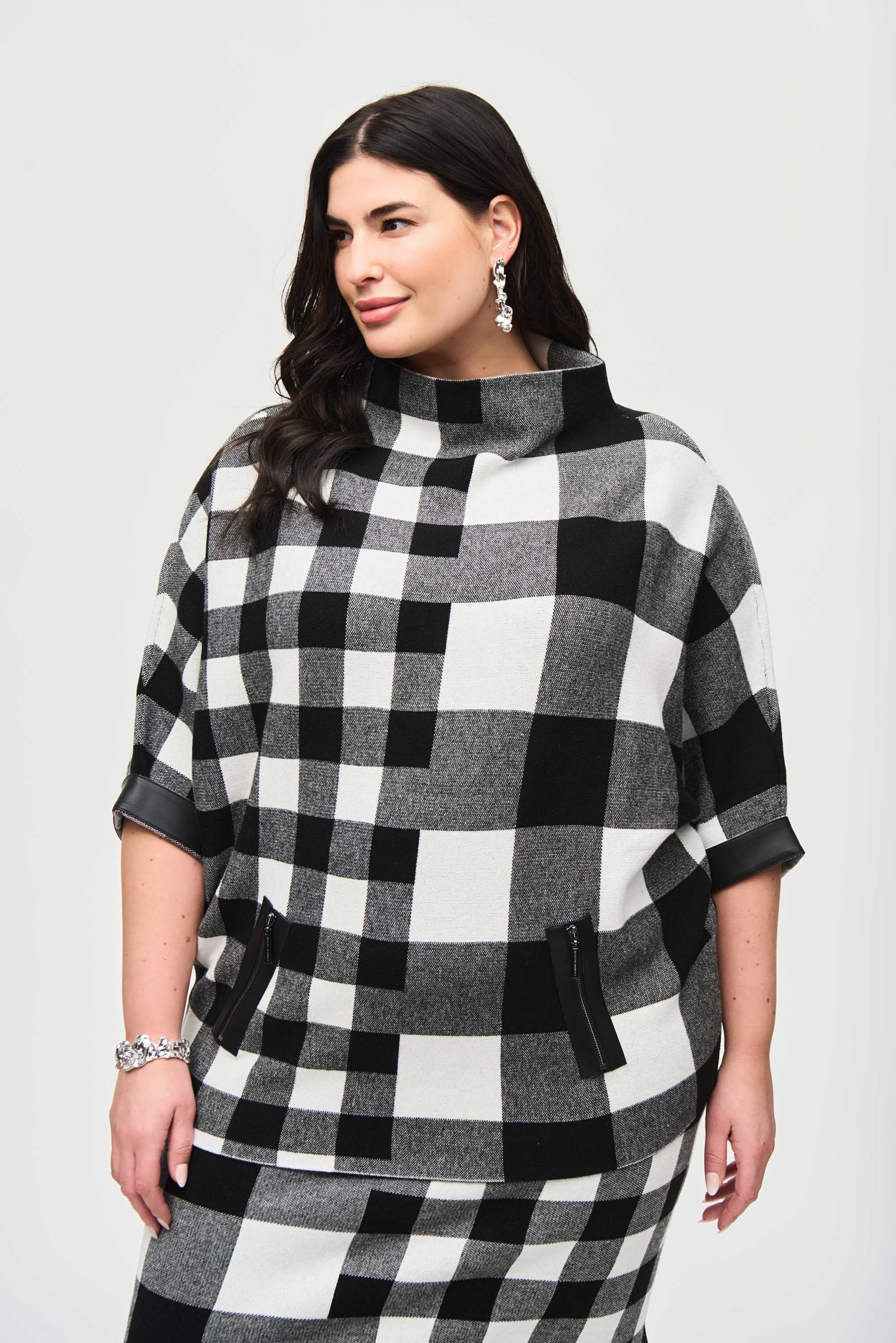 Pearls Boutique - Port Dover Ontario - Joseph Ribkoff - Plaid Jacquard Knit Sweater 243946. Designer: Joseph Ribkoff Style: Chic sweater Neckline: Trendy mock neck Fit: Roomy oversized fit Sleeves: 3/4 straight sleeves Pattern: Charming gingham and marled Detail: Practical zipper Material: 50% Viscose Rayon 28% Nylon 22% Polyester Occasion: Elevates casual wardrobe with comfort and sophistication.Colour Blk/Wht Check 