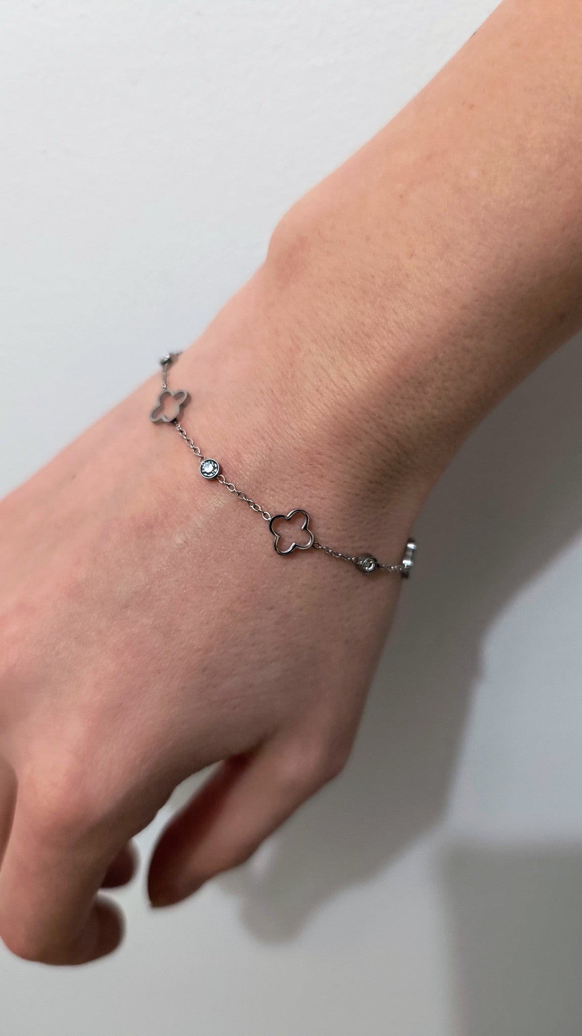 Floating clover bracelet with crystal details.