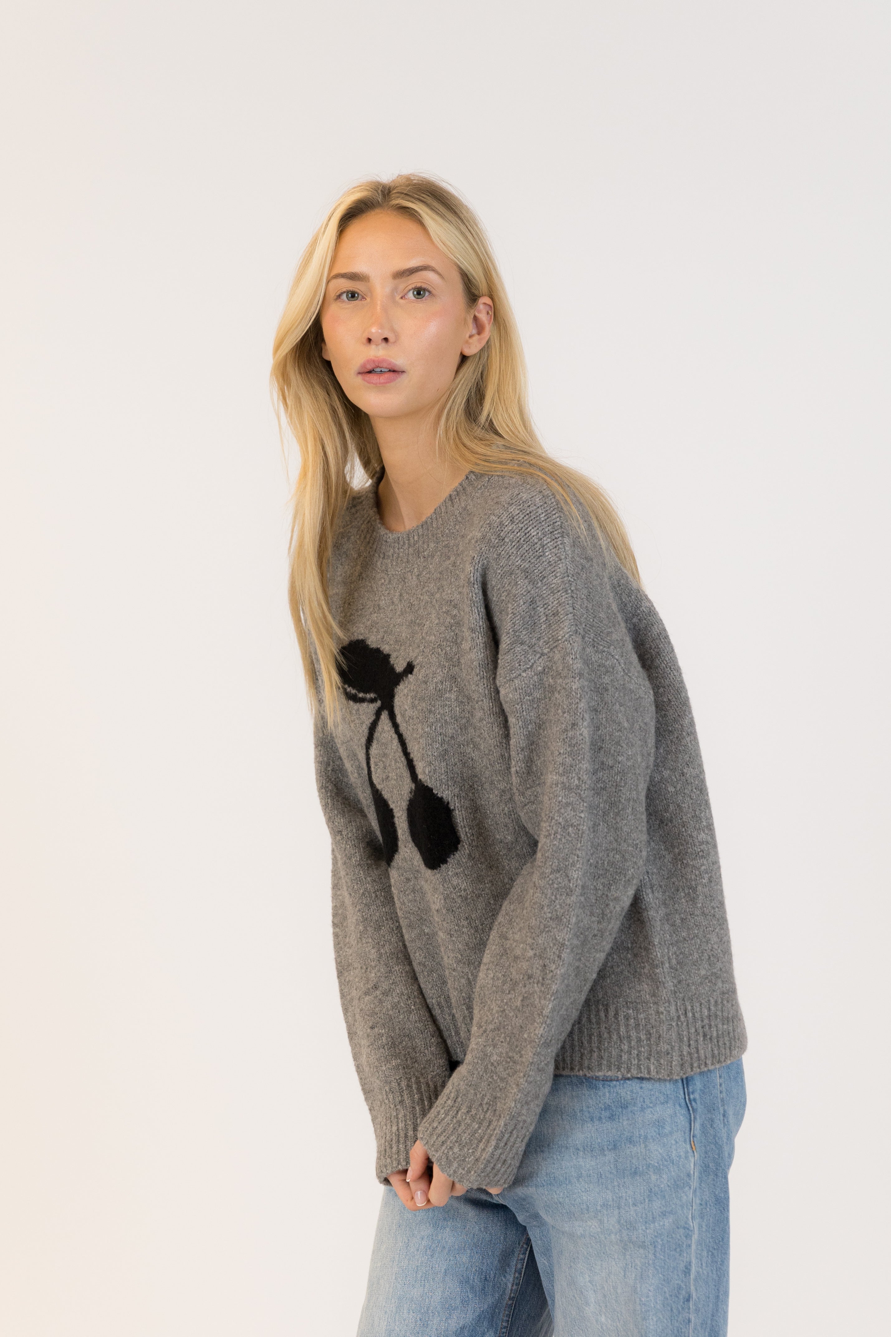 Pearls Boutique| Port Dover Ontario| Lyla + Lux | Lou Crewneck Pullover| women’s crewneck pullover sweater in a charcoal grey knit, featuring playful black cherry embroidery across the front. polyester, acrylic, polyamide, wool, and elastane, this sweater is designed with a classic crew neckline, dropped shoulders, and a relaxed fit for laid-back comfort. The plush, breathable fabric makes it perfect for layering or wearing on its own, adding a subtle yet fun detail to casual fall and winter outfits.