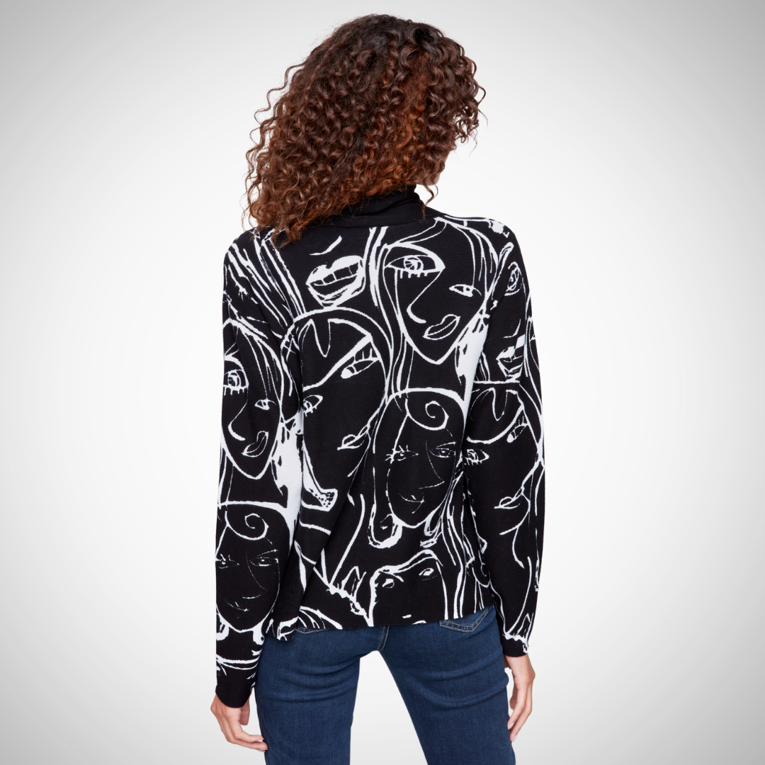 Pearls Boutique - Port Dover Ontario - Charlie B - Faces Sweater, Mock Neck, Drawstring Detail At neck, Black/White colour, relaxed fit. Pullover Printed stitch mock neck Front pocket Long sleeves Abstract faces design in white on black base Cozy, artsy, and fashionable