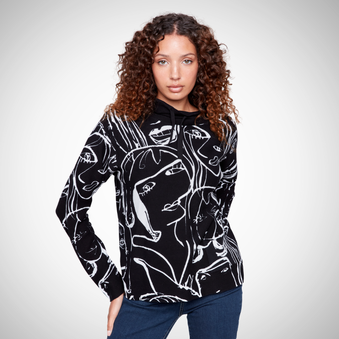 Pearls Boutique - Port Dover Ontario - Charlie B - Faces Sweater, Mock Neck, Drawstring Detail At neck, Black/White colour, relaxed fit. Pullover Printed stitch mock neck Front pocket Long sleeves Abstract faces design in white on black base Cozy, artsy, and fashionable