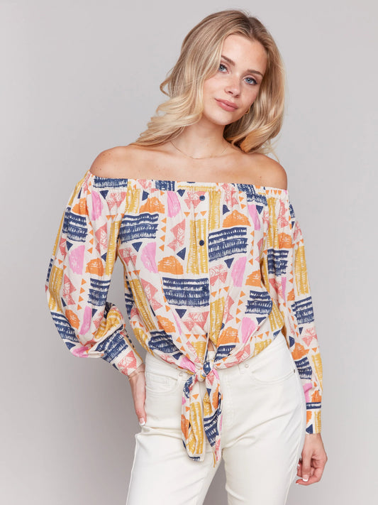 Pearls Boutique-Port Dover Ontario-Charlie B-Off-The-Shoulder Printed Blouse with Front Tie - Batik.
Vibrant off-the-shoulder blouse featuring a playful batik-inspired print. 100% viscose,lightweight and airy top,relaxed fit ,button-down front and front tie knot for a chic touch.  long sleeves.