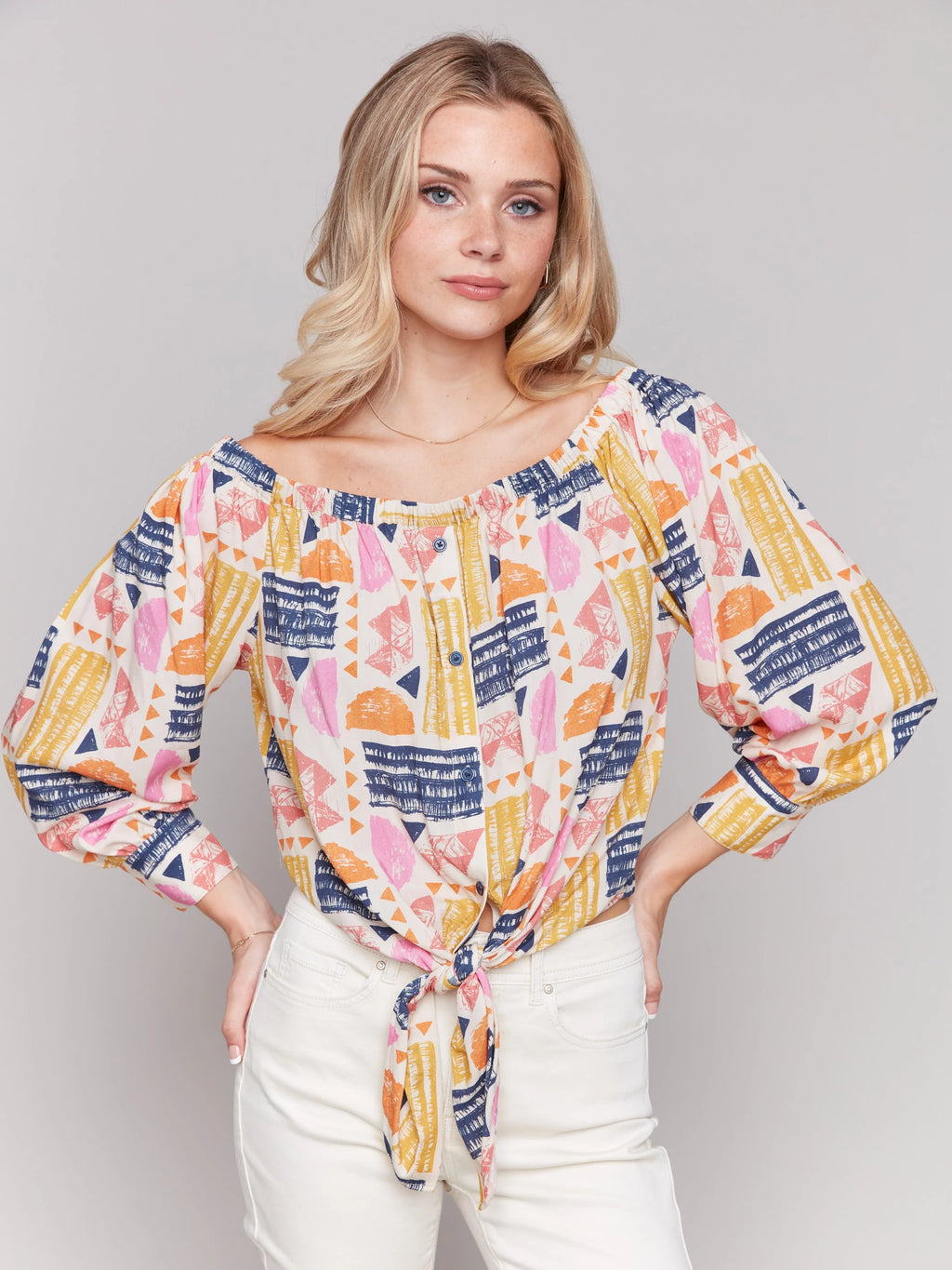 Pearls Boutique-Port Dover Ontario-Charlie B-Off-The-Shoulder Printed Blouse with Front Tie - Batik.
Vibrant off-the-shoulder blouse featuring a playful batik-inspired print. 100% viscose,lightweight and airy top,relaxed fit ,button-down front and front tie knot for a chic touch.  long sleeves.