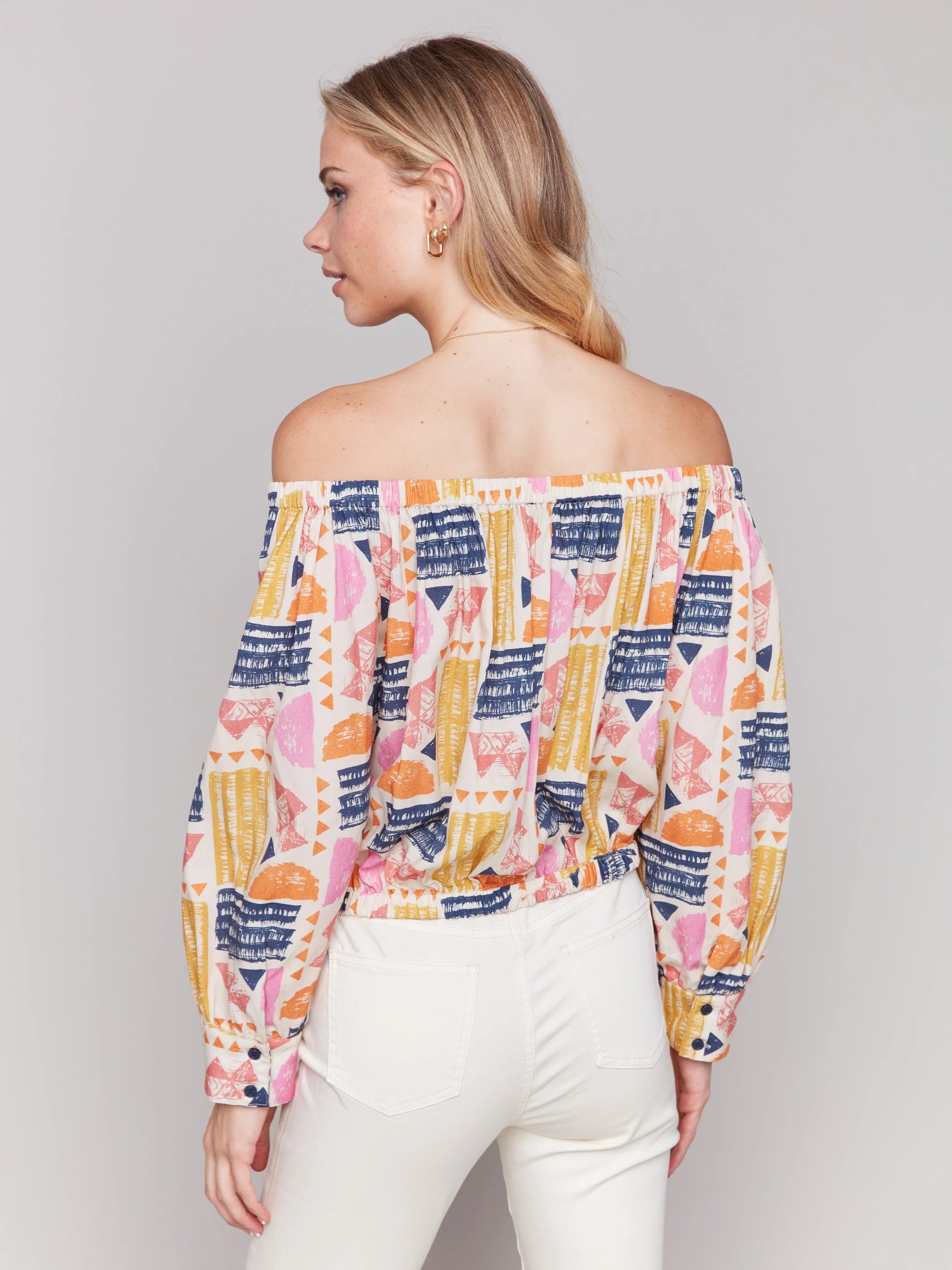 Pearls Boutique-Port Dover Ontario-Charlie B-Off-The-Shoulder Printed Blouse with Front Tie - Batik.
Vibrant off-the-shoulder blouse featuring a playful batik-inspired print. 100% viscose,lightweight and airy top,relaxed fit ,button-down front and front tie knot for a chic touch.  long sleeves.