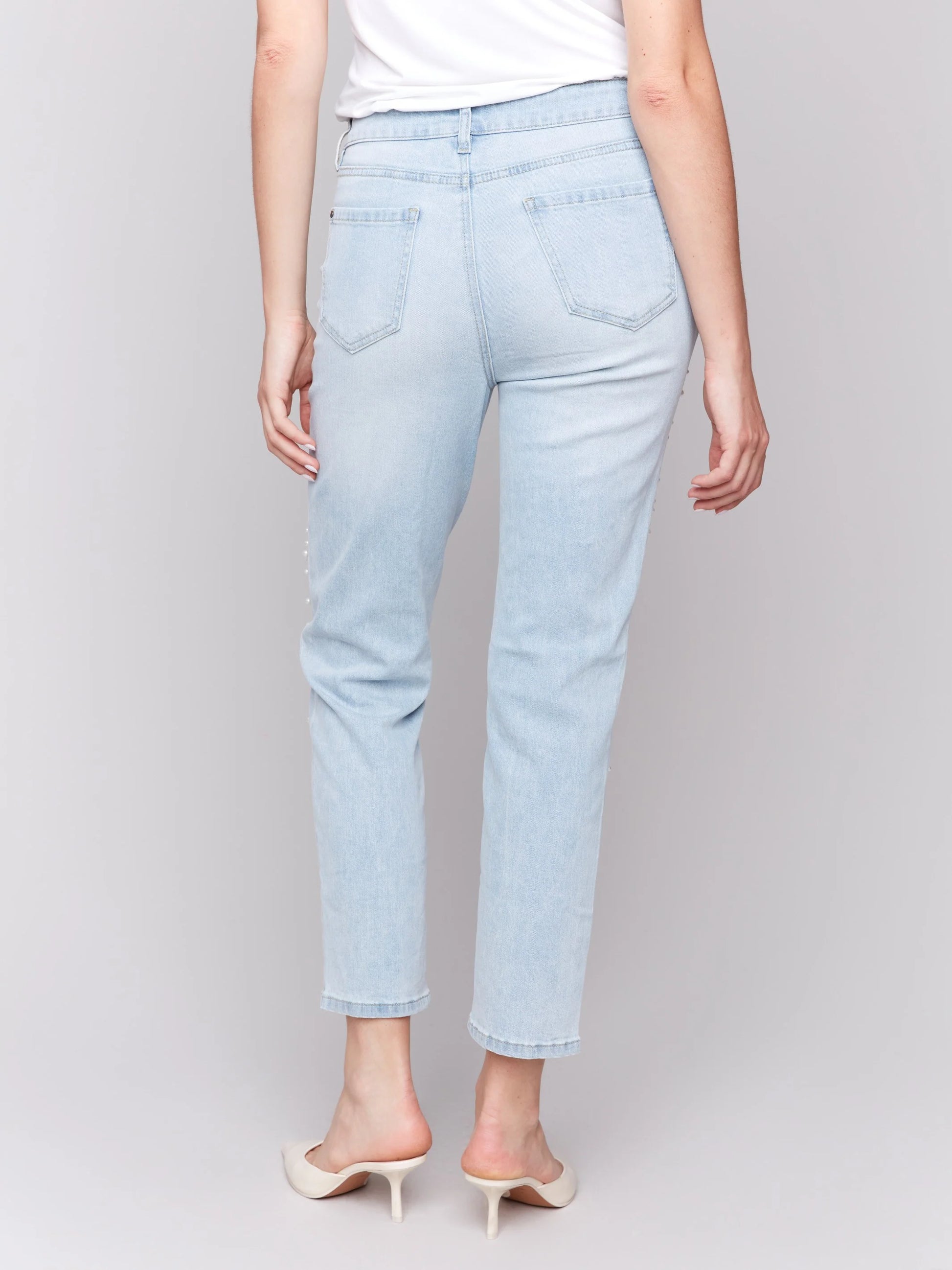 Pearls Boutique-Port Dover Ontario-Charlie B Pearl Applique Slim-Leg Jeans with Distressed Detail-light Blue-Style C5617-301B
Light blue slim-fit jeans with ankle-length cut

Distressed details with delicate pearl appliqué

Regular-rise waist for a flattering fit

Five-pocket design for everyday functionality
Made from stretch denim for comfort and flexibility

Chic blend of elegance and edgy style