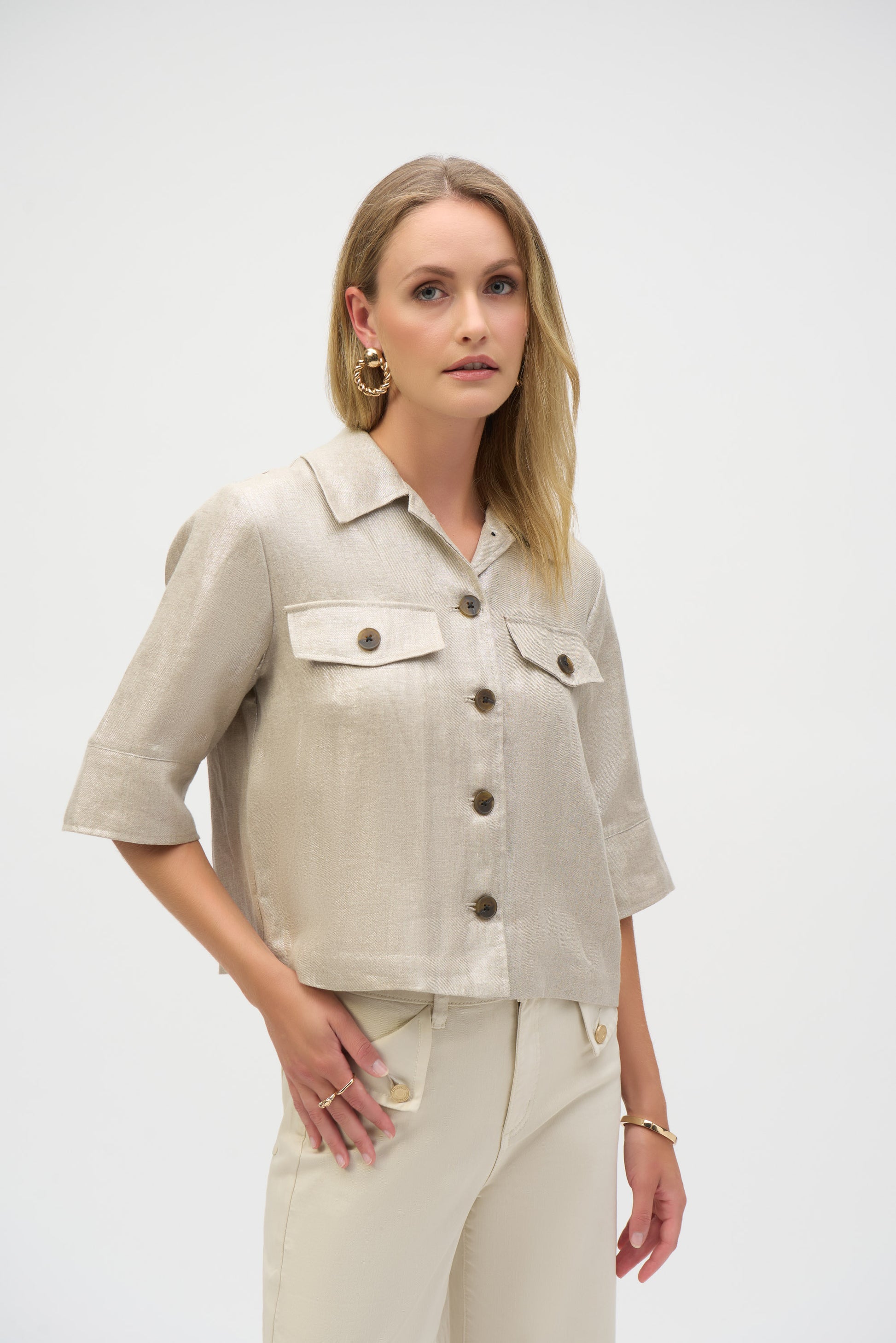 Pearls Boutique-Port Dover Ontario-Joseph Ribkoff-Foiled Linen Jacket-252921.A 100% linen Jacket in a pale gold woven foiled linen blend fabric, featuring a classic shirt collar and 3/4 cuffed sleeves. Designed with a front button closure, flap chest pockets, and contrast buttons. Unlined with a cropped boxy silhouette for a relaxed fit. Can be worn as a shirt or layered as a jacket. Care instructions include hand washing in cold water, avoiding bleach and tumble drying, and low ironing only if needed.
