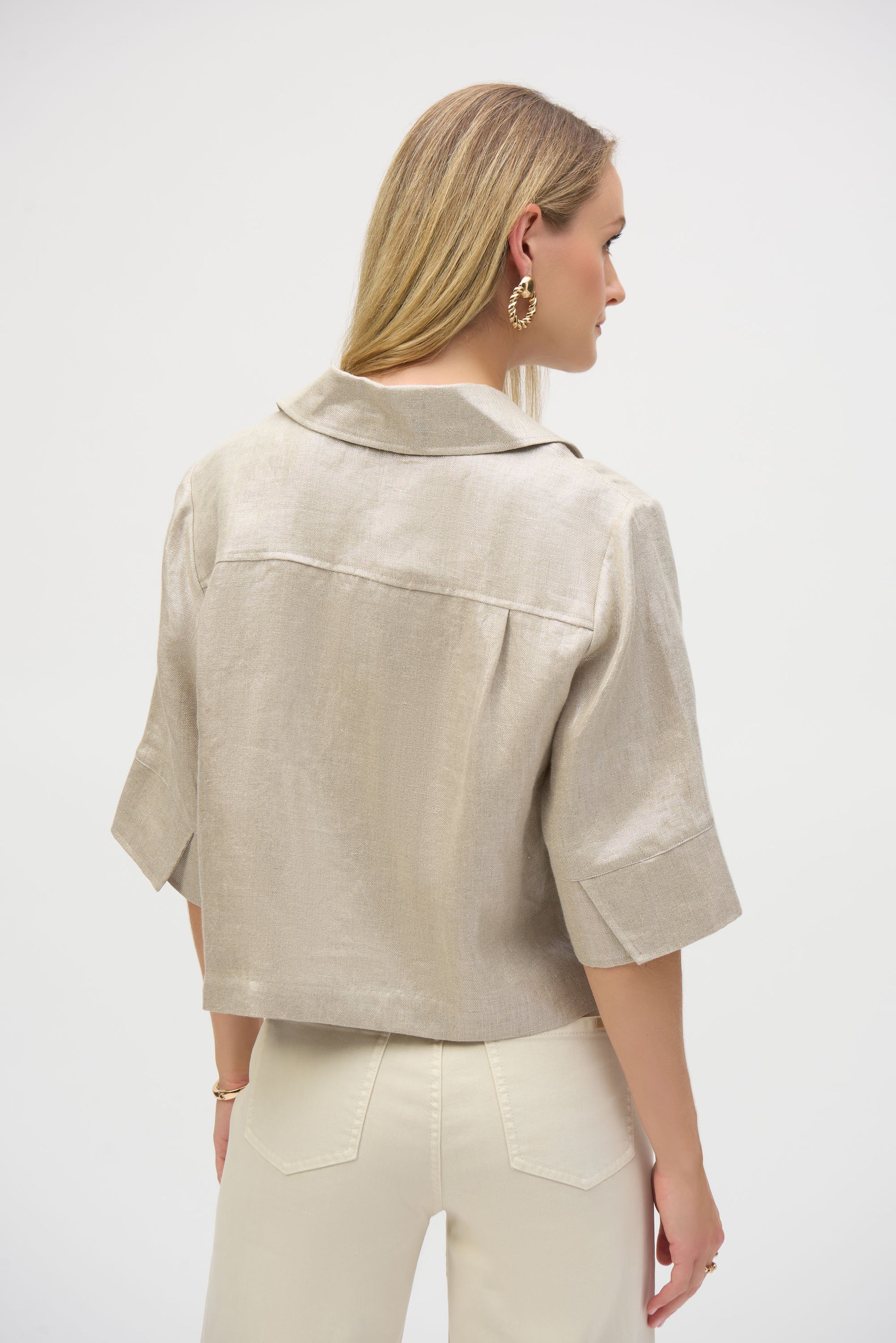 Pearls Boutique-Port Dover Ontario-Joseph Ribkoff-Foiled Linen Jacket-252921.A 100% linen Jacket in a pale gold woven foiled linen blend fabric, featuring a classic shirt collar and 3/4 cuffed sleeves. Designed with a front button closure, flap chest pockets, and contrast buttons. Unlined with a cropped boxy silhouette for a relaxed fit. Can be worn as a shirt or layered as a jacket. Care instructions include hand washing in cold water, avoiding bleach and tumble drying, and low ironing only if needed.
