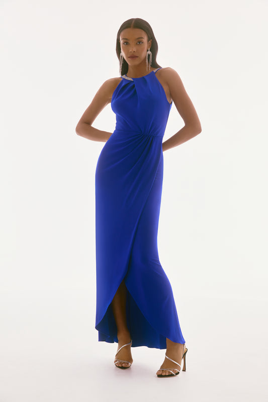 Pearls Boutique-Port Dover Ontario-Joseph Ribkoff Gown 251709 in Royal Sapphire
 stunning evening gown designed for weddings, galas, and black-tie events.
 Halter Neckline – High-neck silhouette with rhinestone embellishments for added sparkle.
Twist Front Detail – Sculpted bodice enhances curves and creates a flattering shape.
Graceful Draping & Flowing Silhouette – Effortless movement with a figure-flattering design.
Thigh-High Slit – A refined yet daring touch, elongating the legs