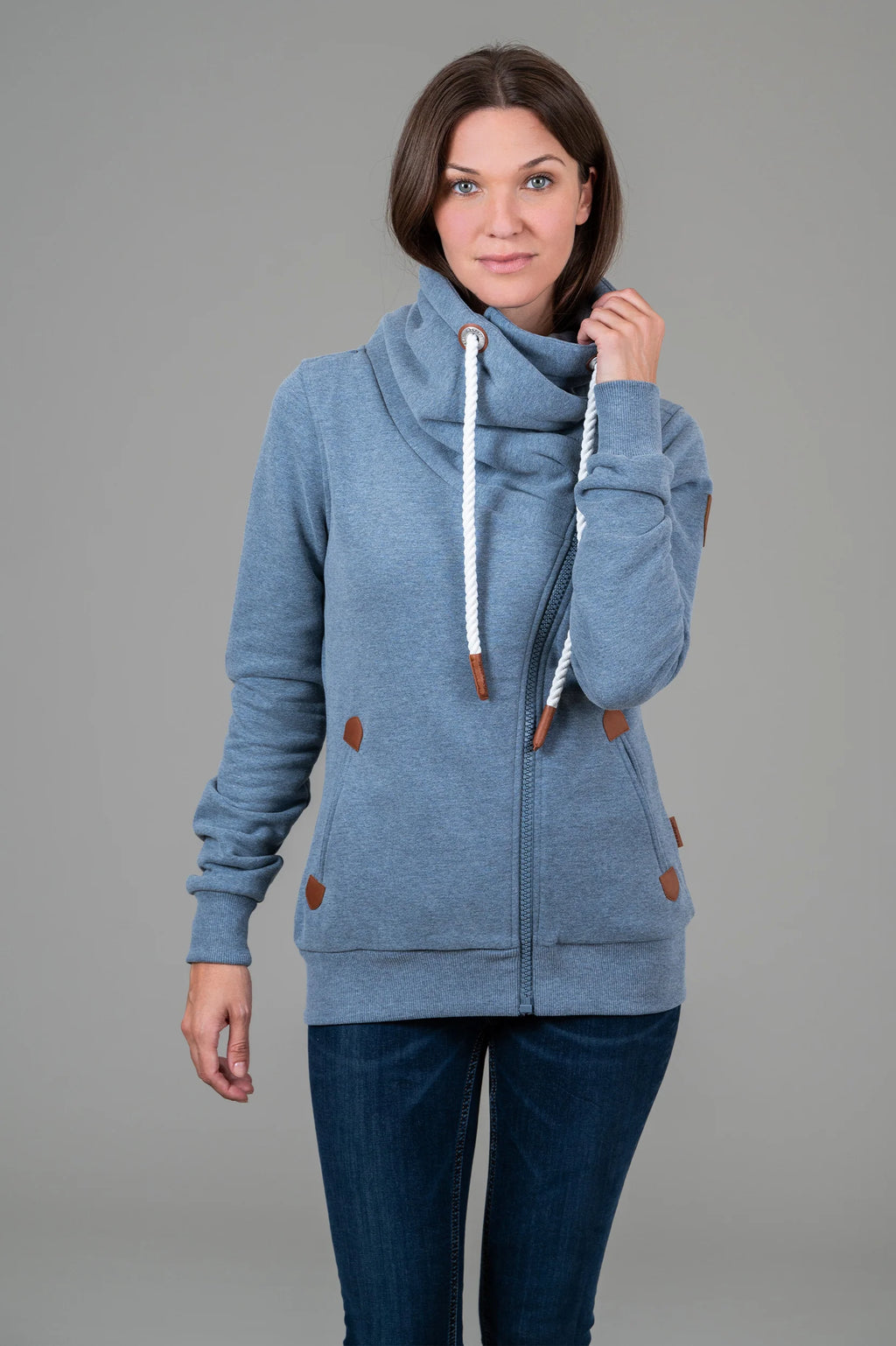 Pearls Boutique-Port Dover Ontario-Wanakome Hestia full-zip sweatshirt-Heather Blue. featuring a contoured fit and soft French terry fabric with a brushed interior. Includes an adjustable hood with thick rope drawstrings and vegan leather caps, a full-length asymmetrical zipper, and ribbed cuffs and hem. Finished with vegan leather Wanakome patch logos on the chest and sleeve, plus roomy front pockets for added comfort.