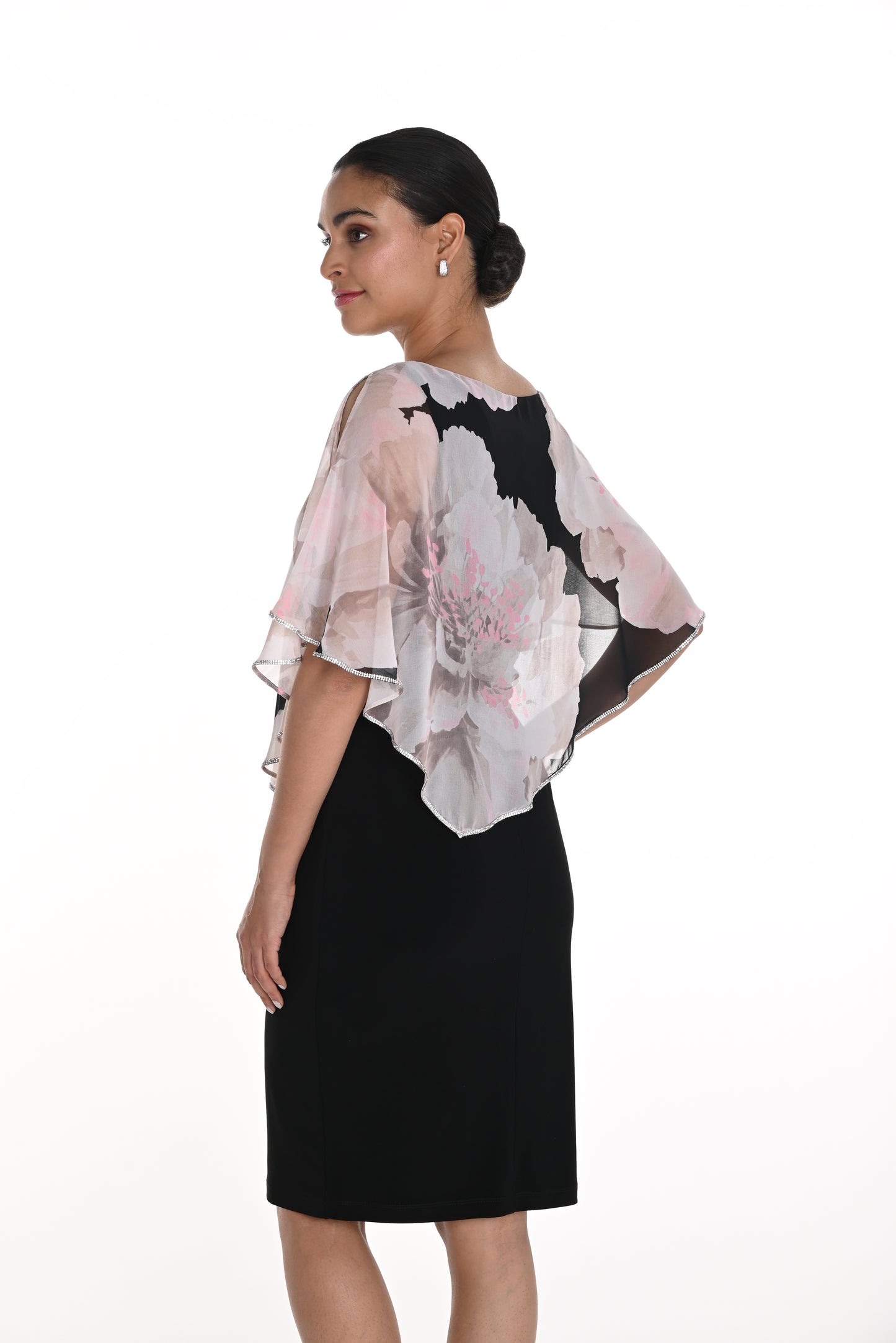 Pearls Boutique-Port Dover Ontario Frank Lyman Knee-Length Dress – Elegant and sophisticated design.
 
Chiffon Cape Overlay – Sheer, flowing fabric drapes over the shoulders.
Floral Print on Cape – Large soft grey and pink flowers with black accents.
Asymmetrical Hem on Cape – Adds movement and a touch of drama.
Boat Neckline –
Short Flutter Sleeves – Light and airy chiffon drapes over arms.
 Trim on Cape Edge has Subtle shimmer Ideal for weddings, parties, or elegant gatherings.






