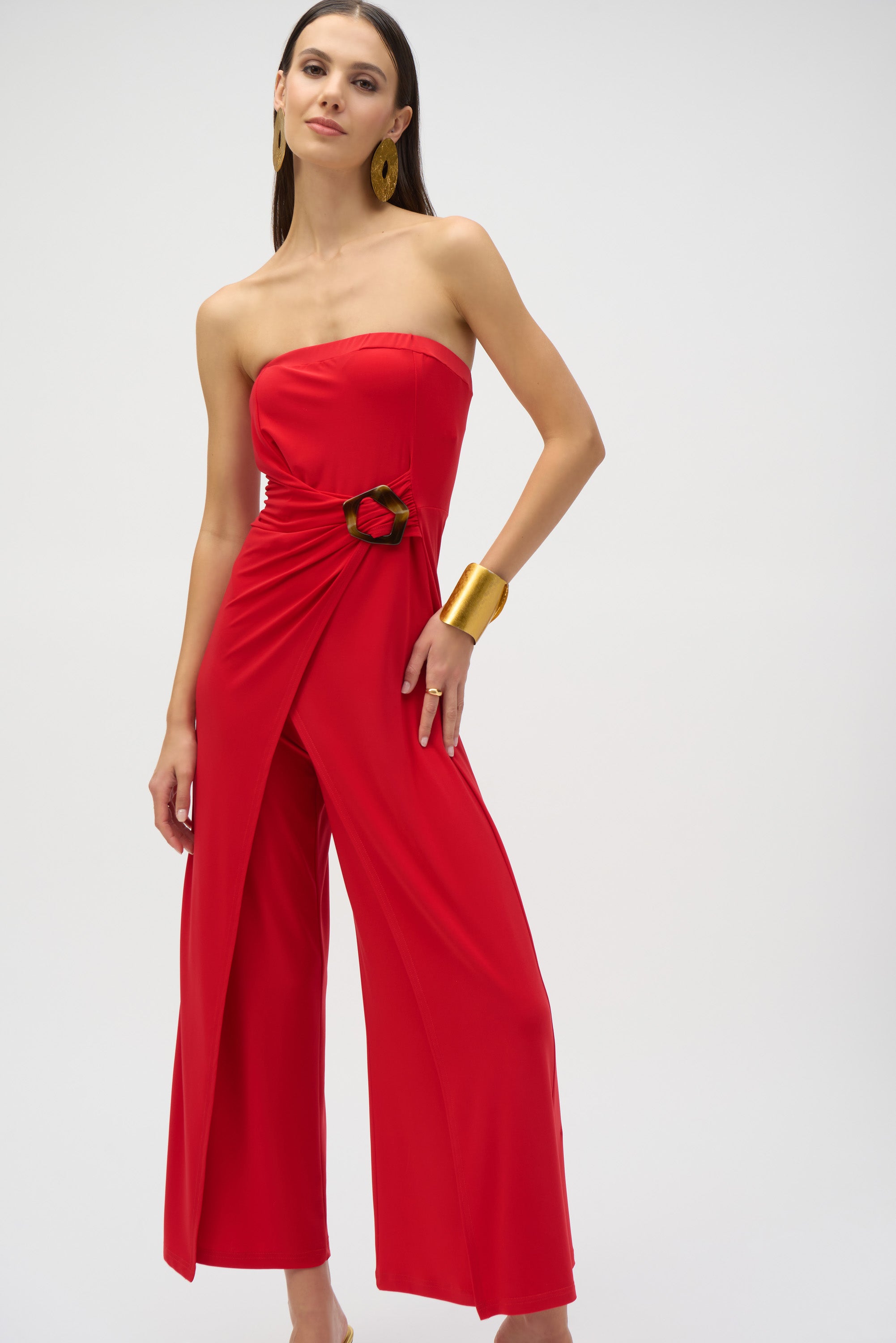 
Pearls Boutique- Port DoverOntario-Joseph Ribkoff- Red silky knit strapless culotte jumpsuit-252083 featuring a bandeau-style bodice with hidden elastic for a perfect fit. Designed with a faux wrap detail and a wide-leg silhouette that adds grace to every movement, the side is elegantly draped and adorned with a faux tortoise shell buckle for a dramatic flair. Unlined for a lightweight feel. Made from 95% polyester and 5% spandex, with easy-care instructions: hand wash, hang to dry, and low iron if needed.