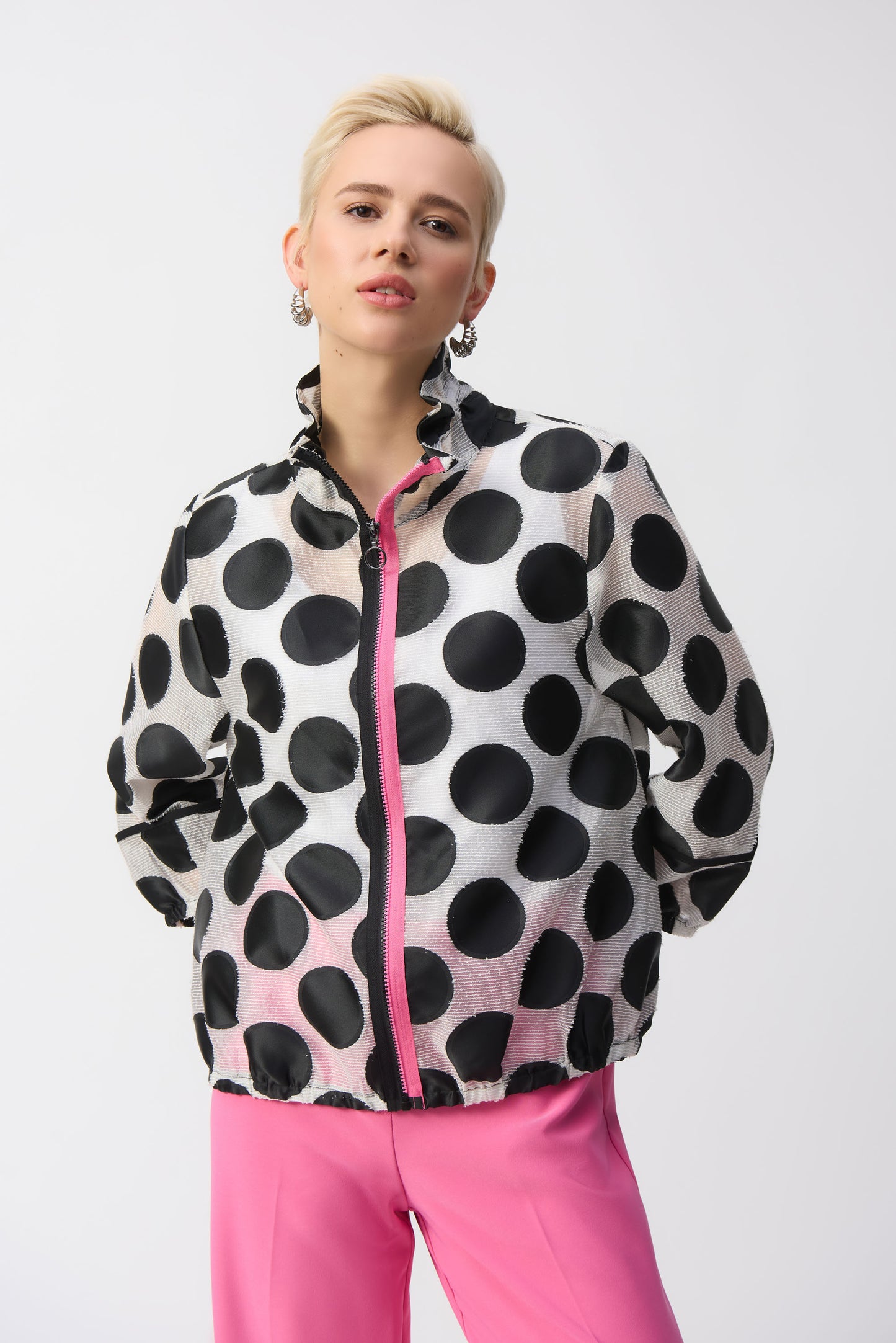Pearls Boutique-Port Dover Ontario-Joseph Ribkoff Jacket 251123 – Black-and-white polka dot jacket with pink zipper accent, made from a lightweight 70% polyester, 15% acrylic, and 15% nylon blend. Relaxed fit with elastic hem for versatile styling. Perfect for casual, work, or evening wear. Made in Canada.