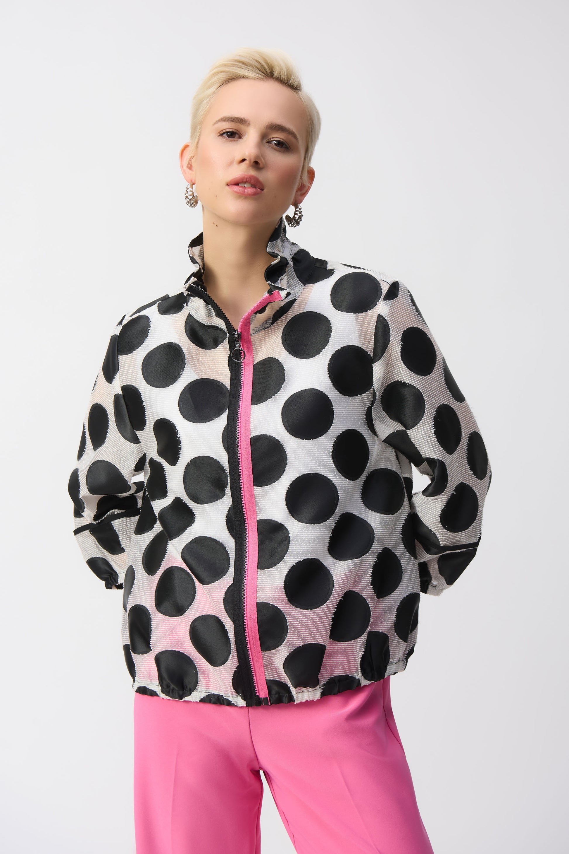 Pearls Boutique-Port Dover Ontario-Joseph Ribkoff Jacket 251123 – Black-and-white polka dot jacket with pink zipper accent, made from a lightweight 70% polyester, 15% acrylic, and 15% nylon blend. Relaxed fit with elastic hem for versatile styling. Perfect for casual, work, or evening wear. Made in Canada.