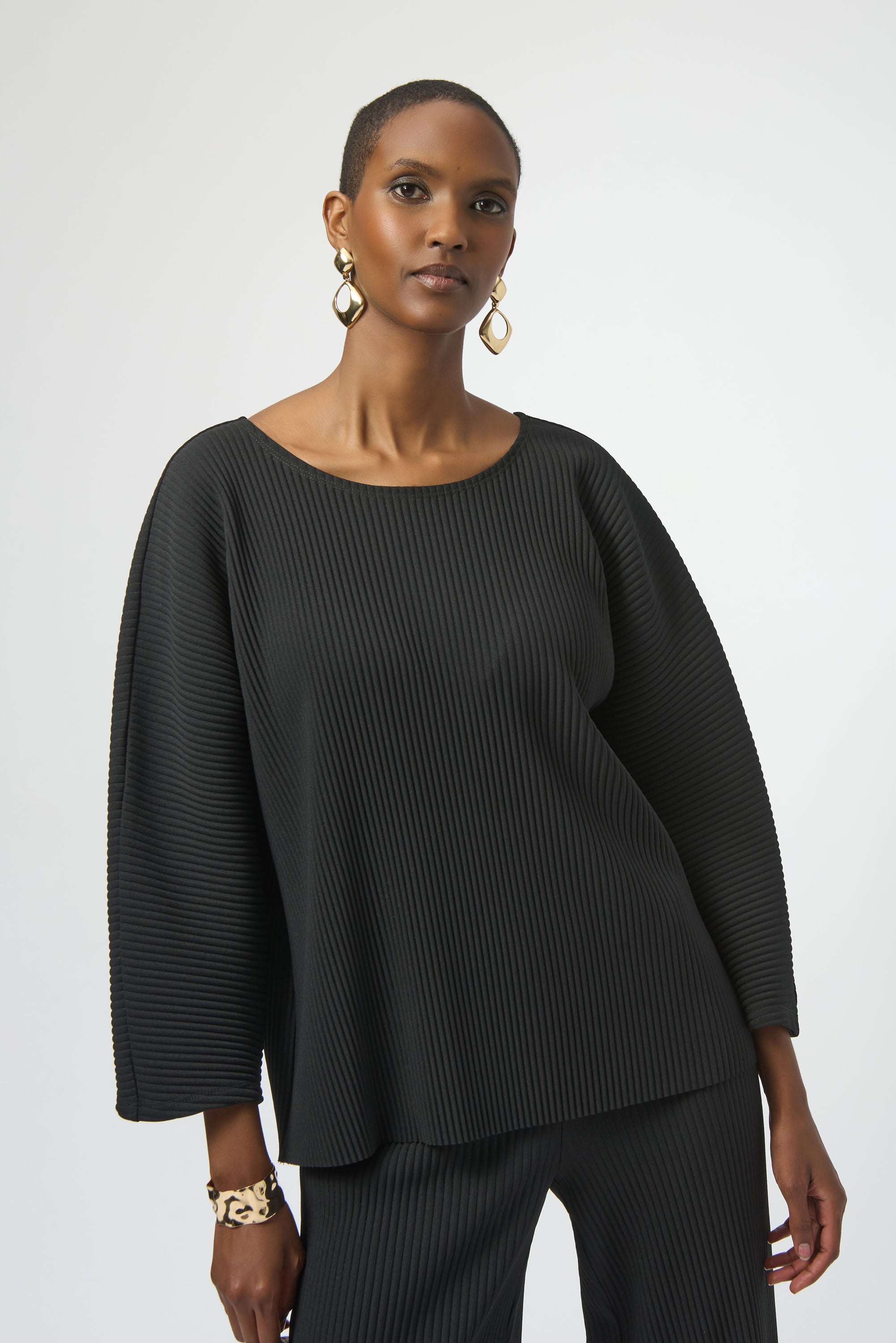 Pearls Boutique-Port Dover Ontario-Joseph Ribkoff | Pleated Scuba Crepe Boxy Top-Colour Black
– Lightweight scuba crepe with subtle structure
– Delicate pleating for added movement and dimension
– Flattering scoop neckline with soft drape
– Three-quarter dolman sleeves for a contemporary finish
– Relaxed, boxy silhouette for all-day comfort