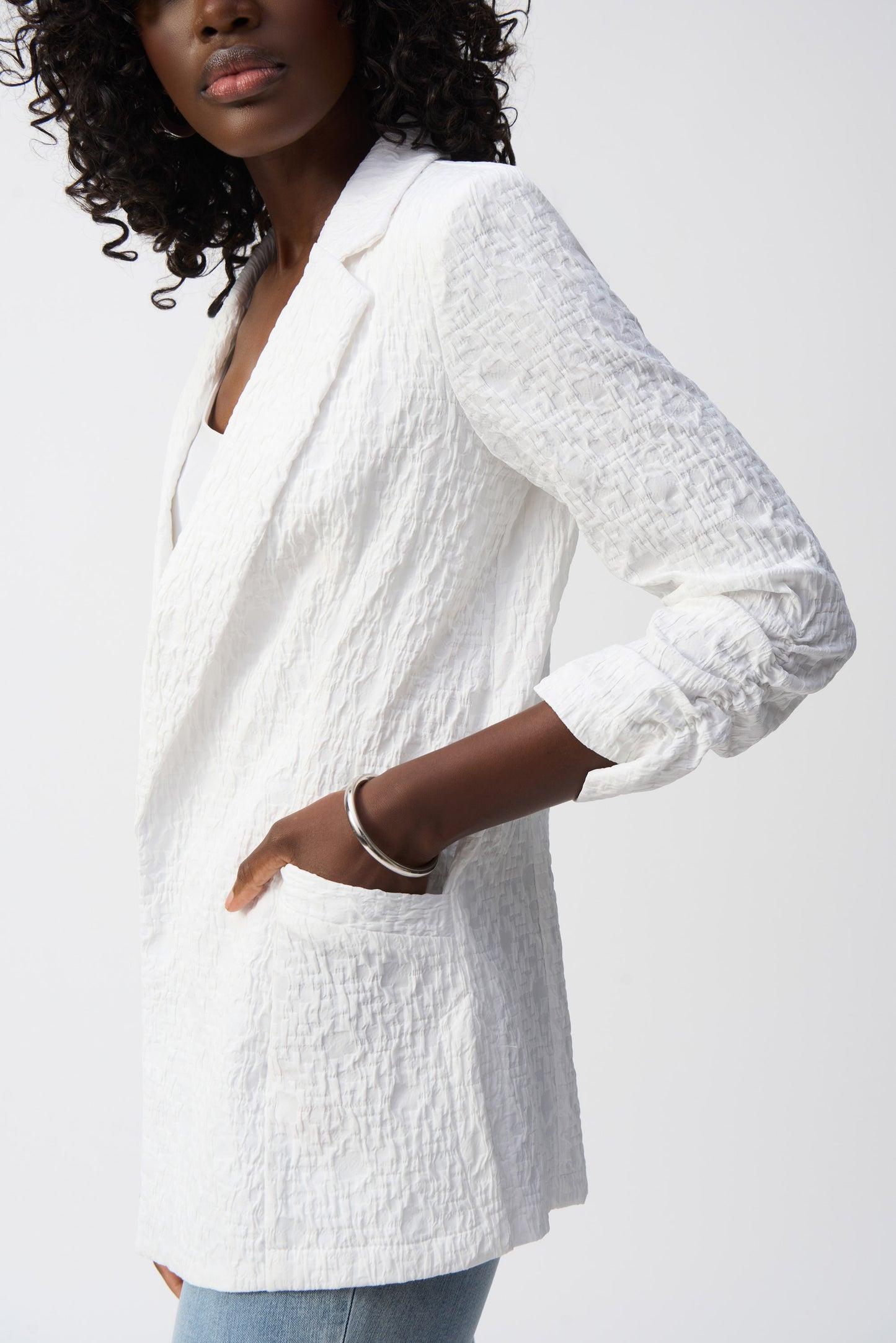 Pearls Boutique- Port Dover Ontario-Joseph Ribkoff White Textured Blazer 242034 Open-front jacket with a polished yet relaxed silhouette for effortless layering, featuring a sophisticated notched lapel for both office and casual wear. Designed with long, straight sleeves for versatile all-season styling. Functional side pockets add practicality without compromising style. Made from a soft, breathable blend of 99% polyester and 1% spandex for all-day comfort.