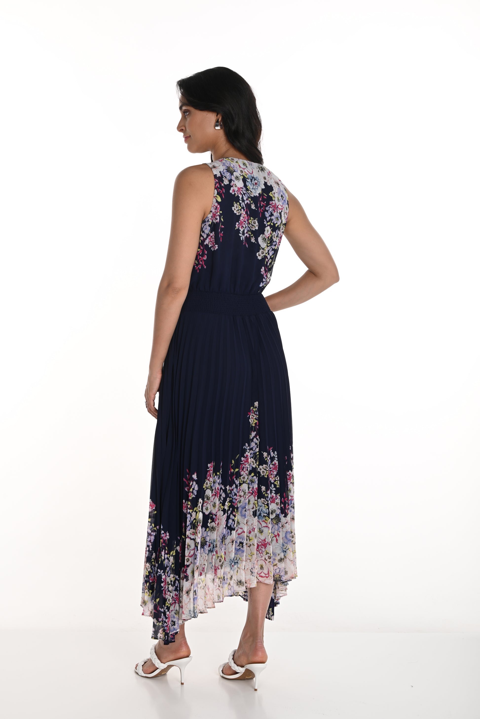 Pearls Boutique - Port Dover Ontario-Frank Lyman Floral Dress (Style 256712U) featuring a navy blue and blush floral pattern. This woven dress has a pleated skirt, relaxed fit, and flowing silhouette, v neckline, sleeveless,offering effortless elegance. Made from 100% polyester, it is lightweight and perfect for spring celebrations. Crafted in Canada
