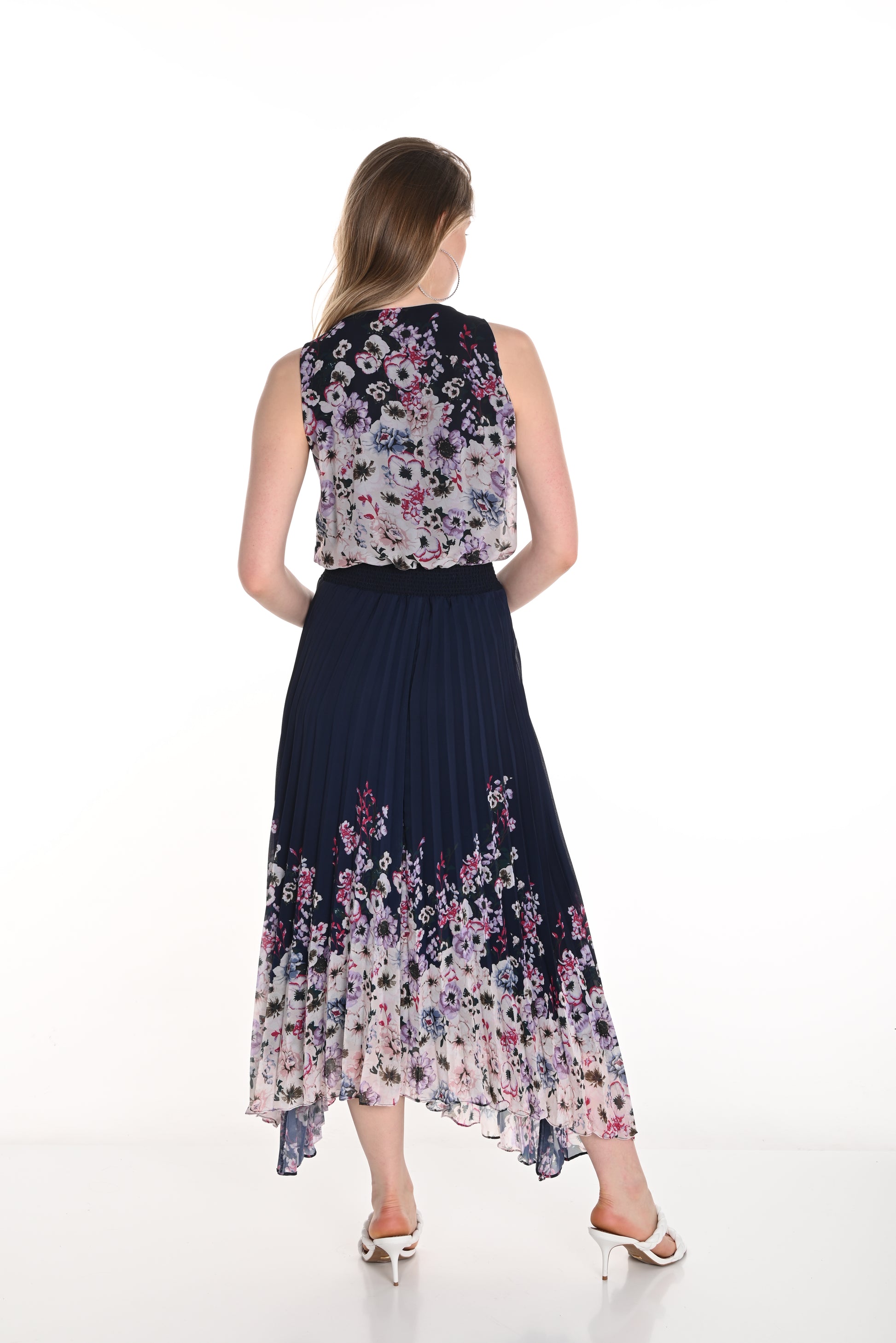 Pearls Boutique - Port Dover Ontario-Frank Lyman Floral Dress (Style 256712U) featuring a navy blue and blush floral pattern. This woven dress has a pleated skirt, relaxed fit, and flowing silhouette, v neckline, sleeveless,offering effortless elegance. Made from 100% polyester, it is lightweight and perfect for spring celebrations. Crafted in Canada