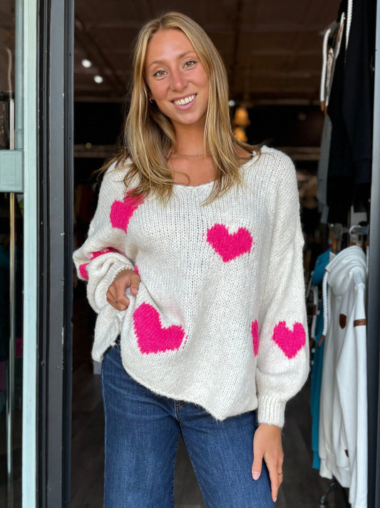 Pearls Boutique -Port Dover Ontario-Hearts Shaker Sweater. 
Whimsical hearts design
Relaxed fit
Drop shoulders
Flattering V-neckline
Vibrant pink hearts on an off-white base
Cozy and playful
A favorite addition to your collection