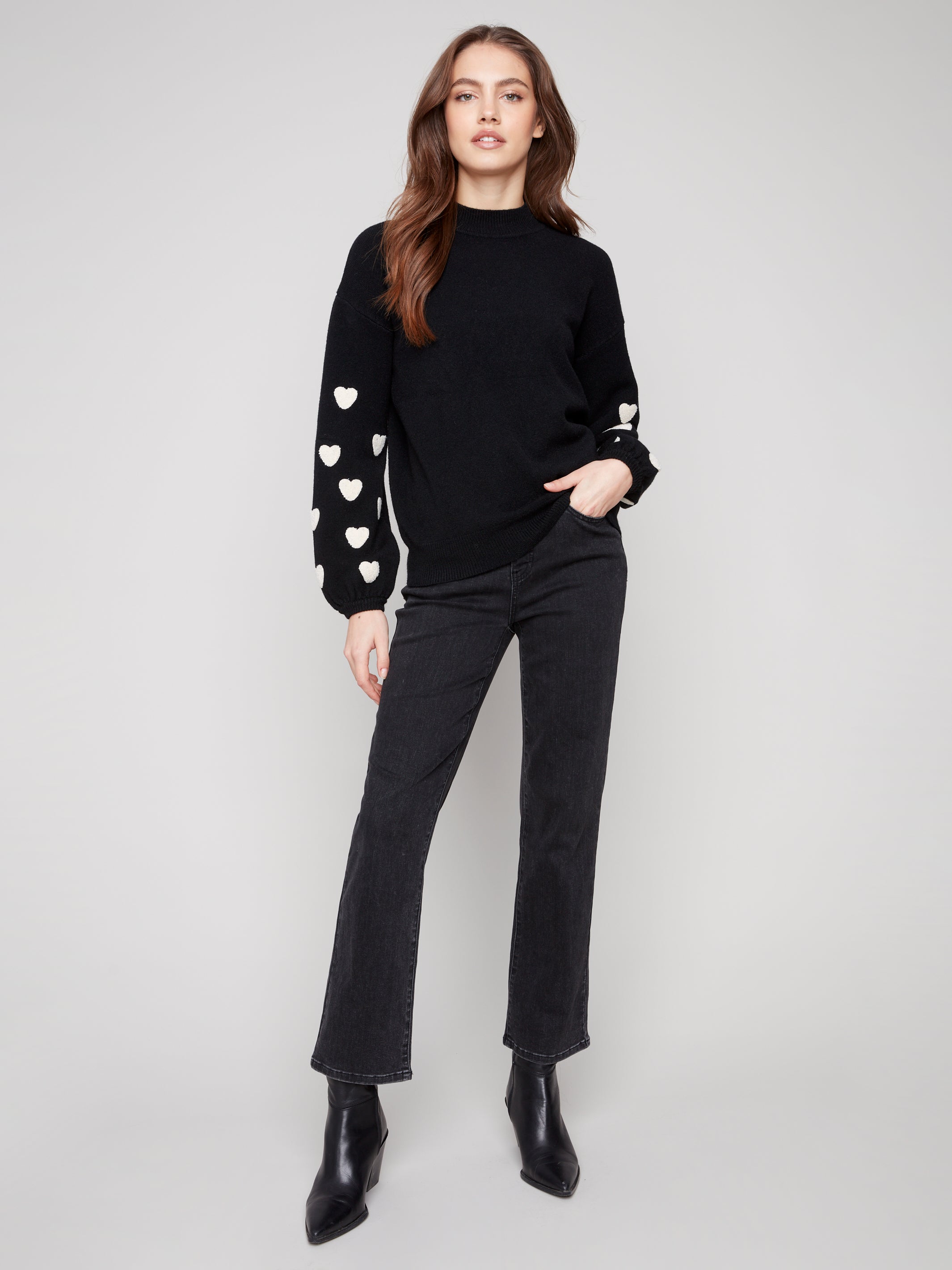 Pearls Boutique | Port Dover Ontario|Charlie B | Mock Neck Sweater With Embroidered Hearts| colour black with white embroidered hearts on sleeves. Mock neck sweater in a soft plush knit, featuring heart embroidery on balloon sleeves, relaxed fit.