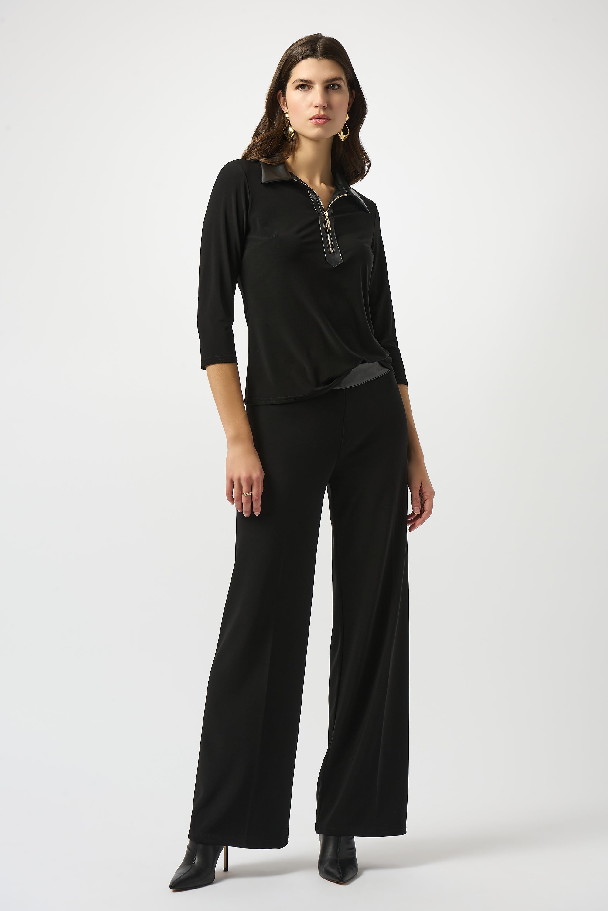 Pearls Boutique Port Dover Ontario Joseph Ribkoff Silky Knit and Leatherette Fitted Top. colour Black Fitted silhouette designed to contour and flatter
Silky knit fabric with a soft, fluid feel
Bold shirt collar with leatherette detailing for modern sophistication
Front placket with zipper accent for a sleek, contemporary edge
Three-quarter sleeves offering a balanced, polished look
Unlined for lightweight, effortless wear