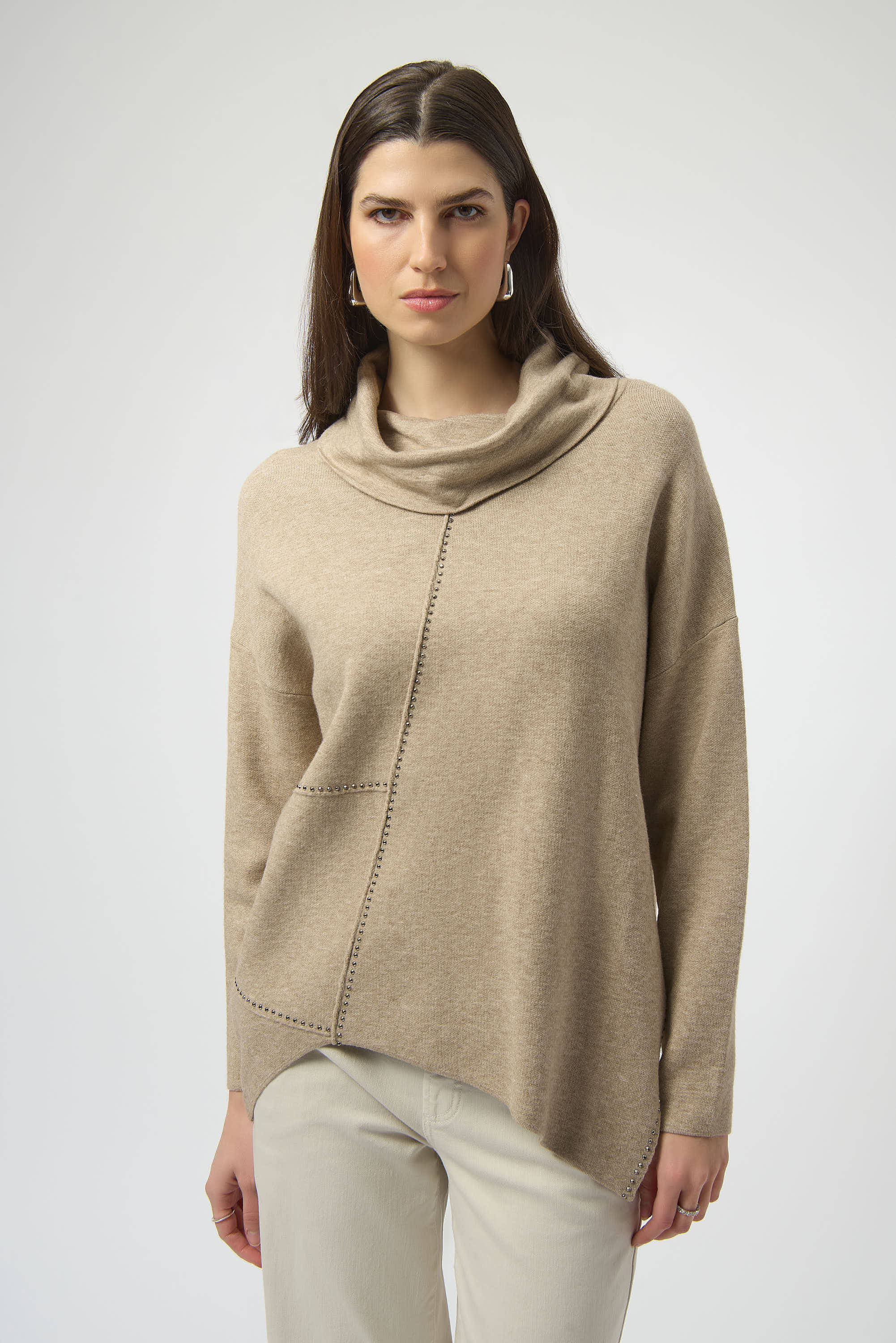 Pearls Boutique| Port Dover Ontario| Joseph Ribkoff |Sweater Knit Oatmeal melange | tunic length sweater. Soft sweater knit with a breathable, luxe texture
 cowl neckline for a cozy and refined drape
Asymmetrical design with hi-low hem for modern movement
Long straight sleeves offering clean, elegant lines
Rhinestone iron-on detailing for a subtle shimmer

FABRIC & FIT
Crafted from a premium blend of viscose, polyamide, and polyester, this pullover ensures a soft hand-feel with a lightweight warmth.

