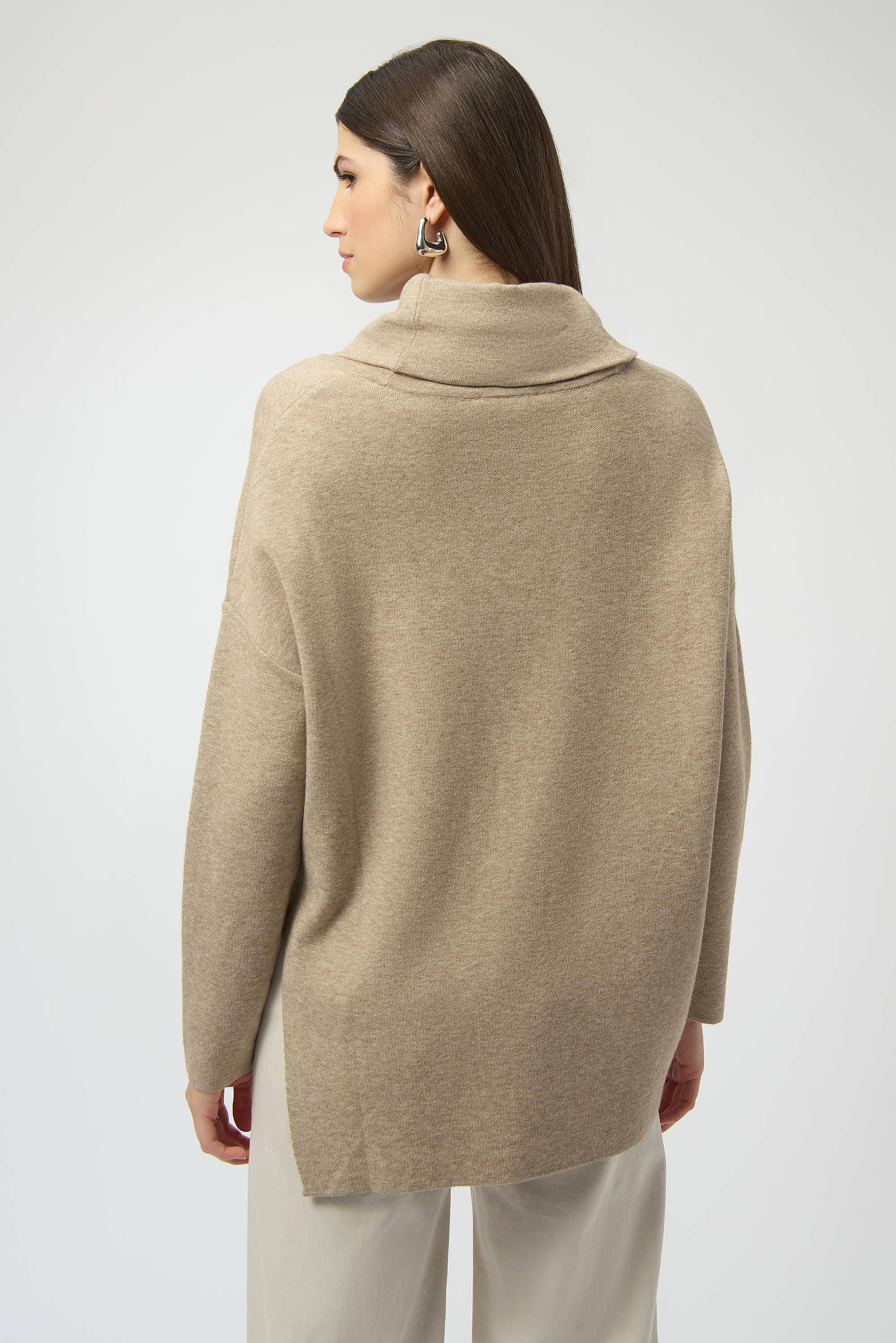 Pearls Boutique| Port Dover Ontario| Joseph Ribkoff |Sweater Knit Oatmeal melange | tunic length sweater. Soft sweater knit with a breathable, luxe texture
 cowl neckline for a cozy and refined drape
Asymmetrical design with hi-low hem for modern movement
Long straight sleeves offering clean, elegant lines
Rhinestone iron-on detailing for a subtle shimmer

FABRIC & FIT
Crafted from a premium blend of viscose, polyamide, and polyester, this pullover ensures a soft hand-feel with a lightweight warmth.

