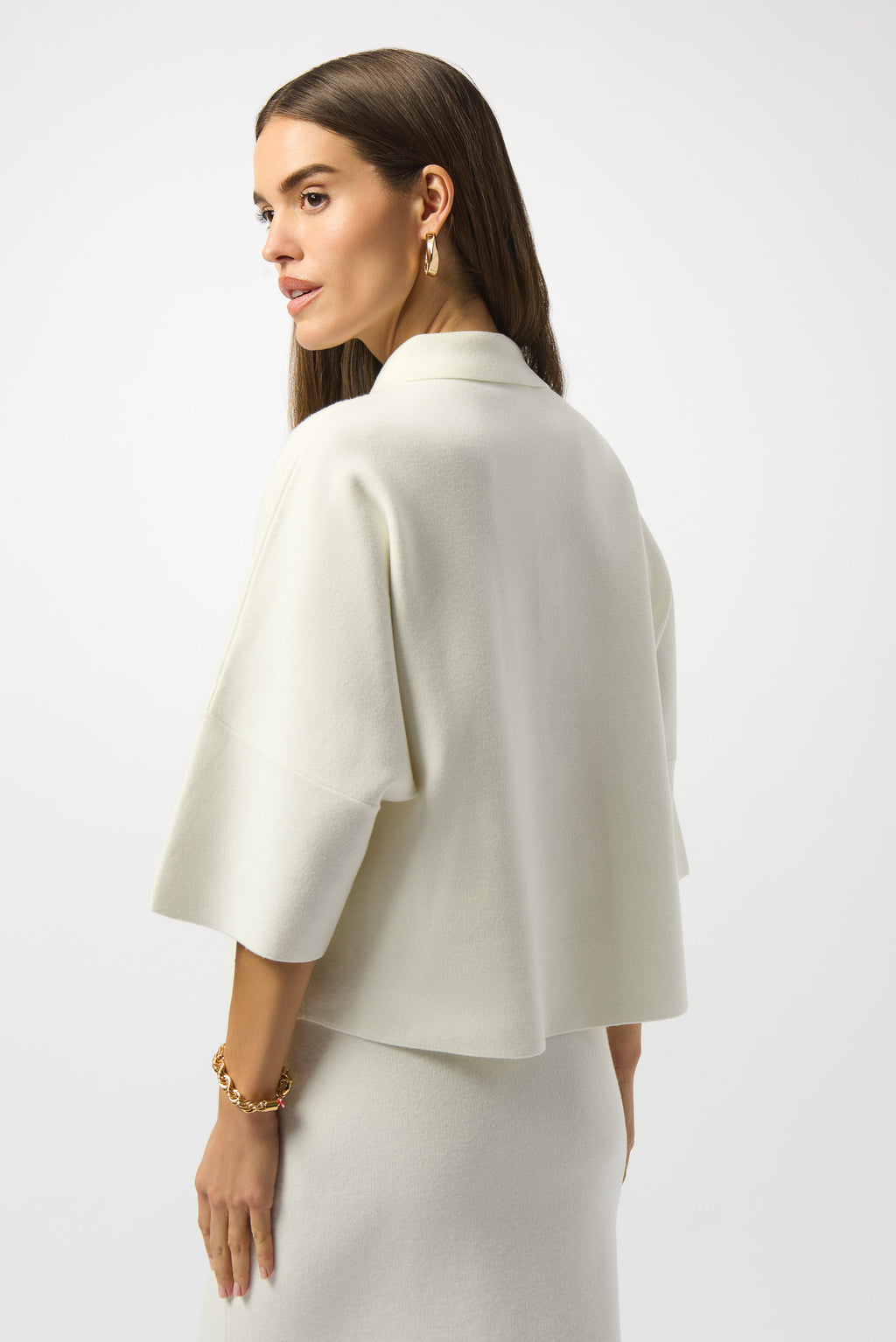 Pearls Boutique|Port Dover Ontario| Joseph Ribkoff | Sweater Knit Boxy Pullover With Polo Collar|253962. Winter white colour. Soft sweater knit pullover featuring a structured boxy fit with a chic polo collar, gold button accents on the placket and front pockets, and elegant three-quarter bell sleeves for a feminine, fluid silhouette.