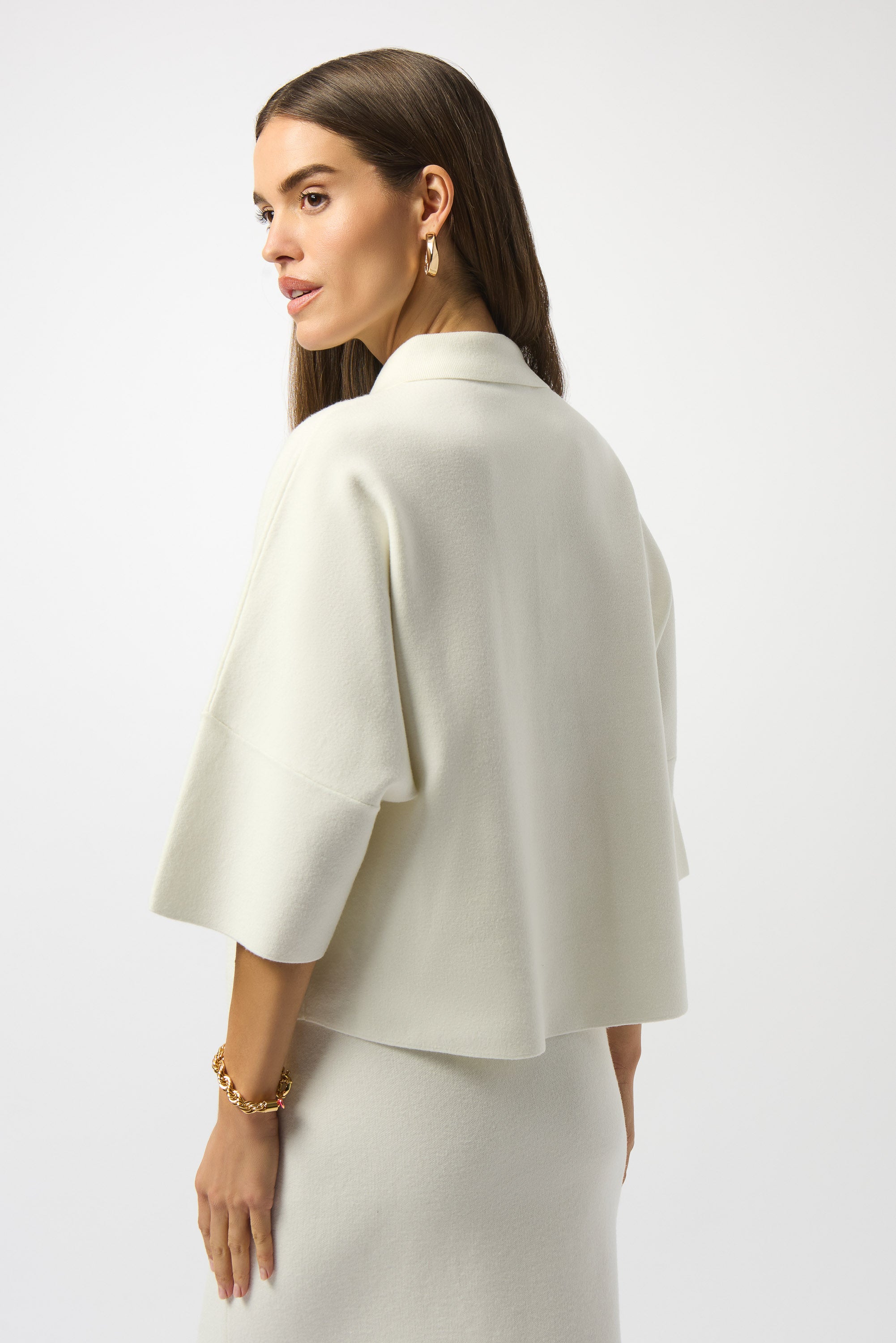 Pearls Boutique|Port Dover Ontario| Joseph Ribkoff | Sweater Knit Boxy Pullover With Polo Collar|253962. Winter white colour. Soft sweater knit pullover featuring a structured boxy fit with a chic polo collar, gold button accents on the placket and front pockets, and elegant three-quarter bell sleeves for a feminine, fluid silhouette.
