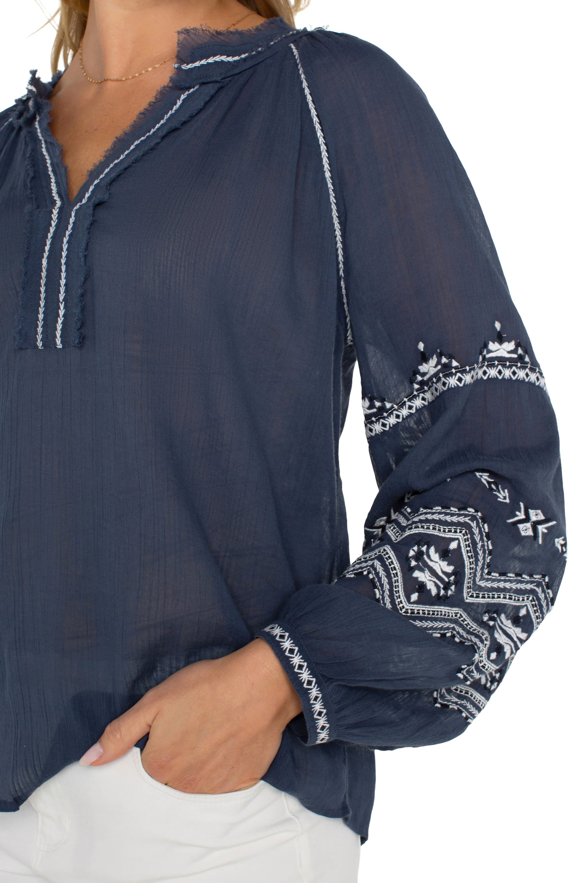 Pearls Boutique| Port Dover Ontario| Liverpool |  Longsleeve Raglan Woven Blouse|LM8F83WV57E1 A dark dusty blue embroidered woven top featuring white embroidery along the raglan sleeves and V-neckline. The top has long raglan sleeves, a V-neck design, and a relaxed, lightweight fit made from 100% cotton