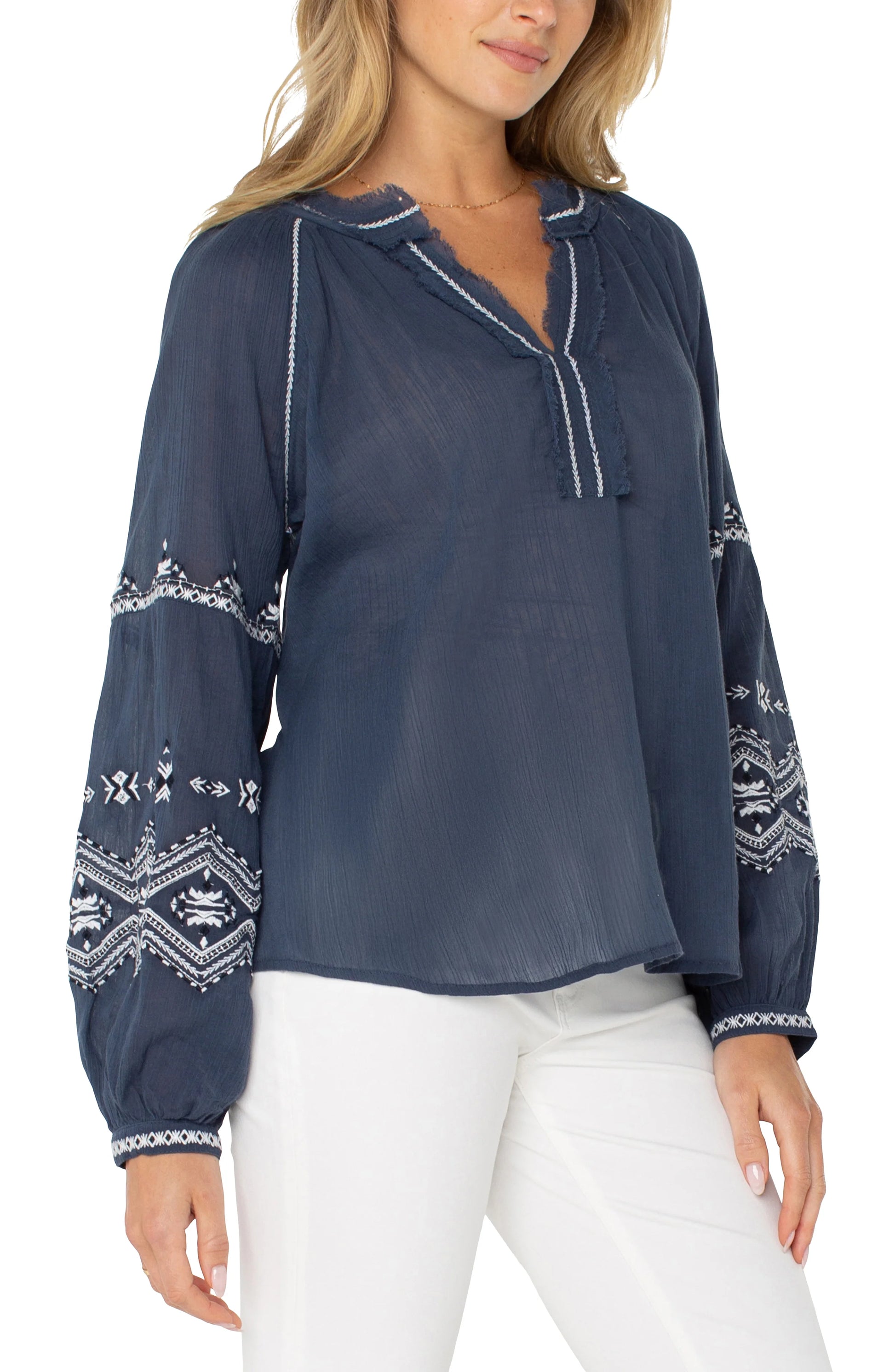 Pearls Boutique| Port Dover Ontario| Liverpool |  Longsleeve Raglan Woven Blouse|LM8F83WV57E1 A dark dusty blue embroidered woven top featuring white embroidery along the raglan sleeves and V-neckline. The top has long raglan sleeves, a V-neck design, and a relaxed, lightweight fit made from 100% cotton