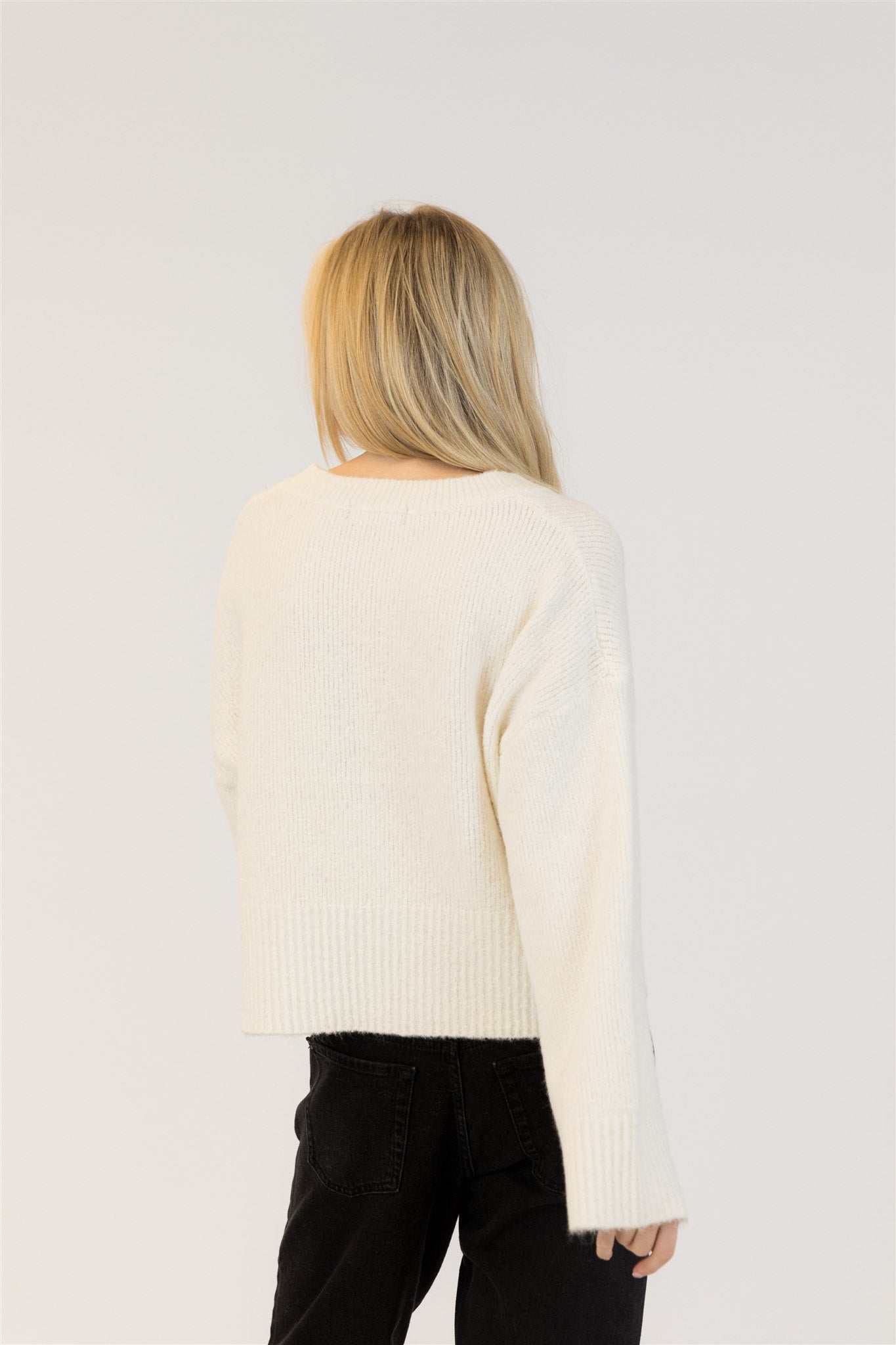 Pearls Boutique | Port Dover Ontario|Lyla + Lux | Eco-Conscious V-Neck Pullover Sweater| colour Ivory.Lyla + Lux women’s V-neck pullover sweater crafted from an eco-conscious blend of recycled polyester, acrylic, polyamide, wool, and elastane. Features a classic V-neckline, long sleeves, and a relaxed fit for effortless layering. The lightweight yet cozy knit offers breathability and softness, 