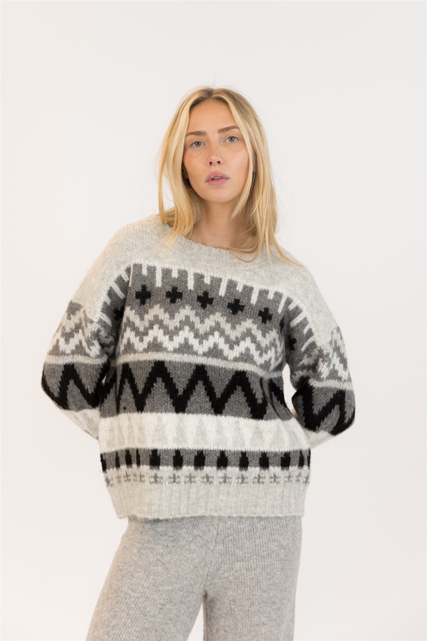 Pearls Boutique| Port Dover Ontario|Lyla + Lux |  Landen Grey Mix Crewneck. Lyla + Lux women’s crewneck pullover sweater featuring a grey and black colour block Aztec design. Classic crew neckline, dropped shoulders, and a relaxed fit for an effortlessly casual silhouette. Crafted from a soft knit blend of acrylic, polyester, and elastane, this sweater offers cozy comfort with a subtle stretch. 