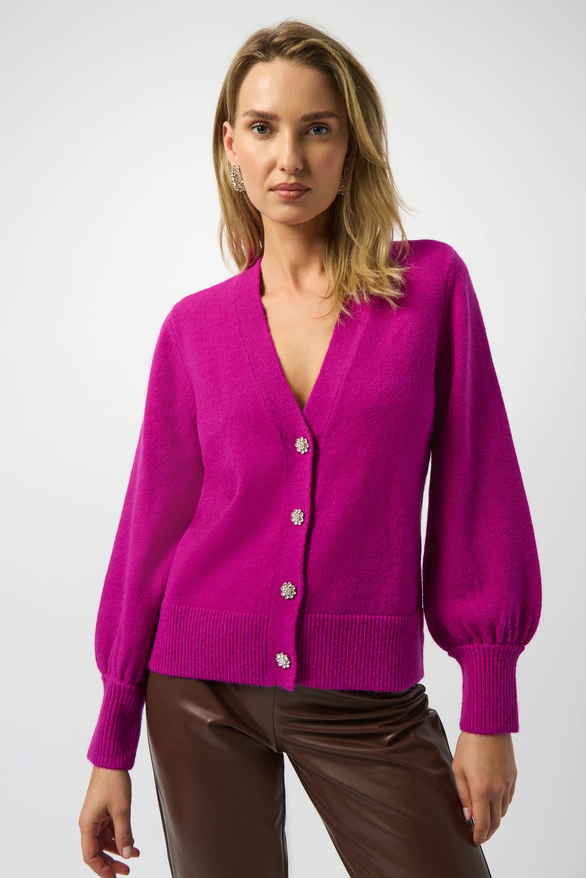 Woman wearing a bright pink cardigan with silver buttons on a white background Pearls Boutique, Port Dover